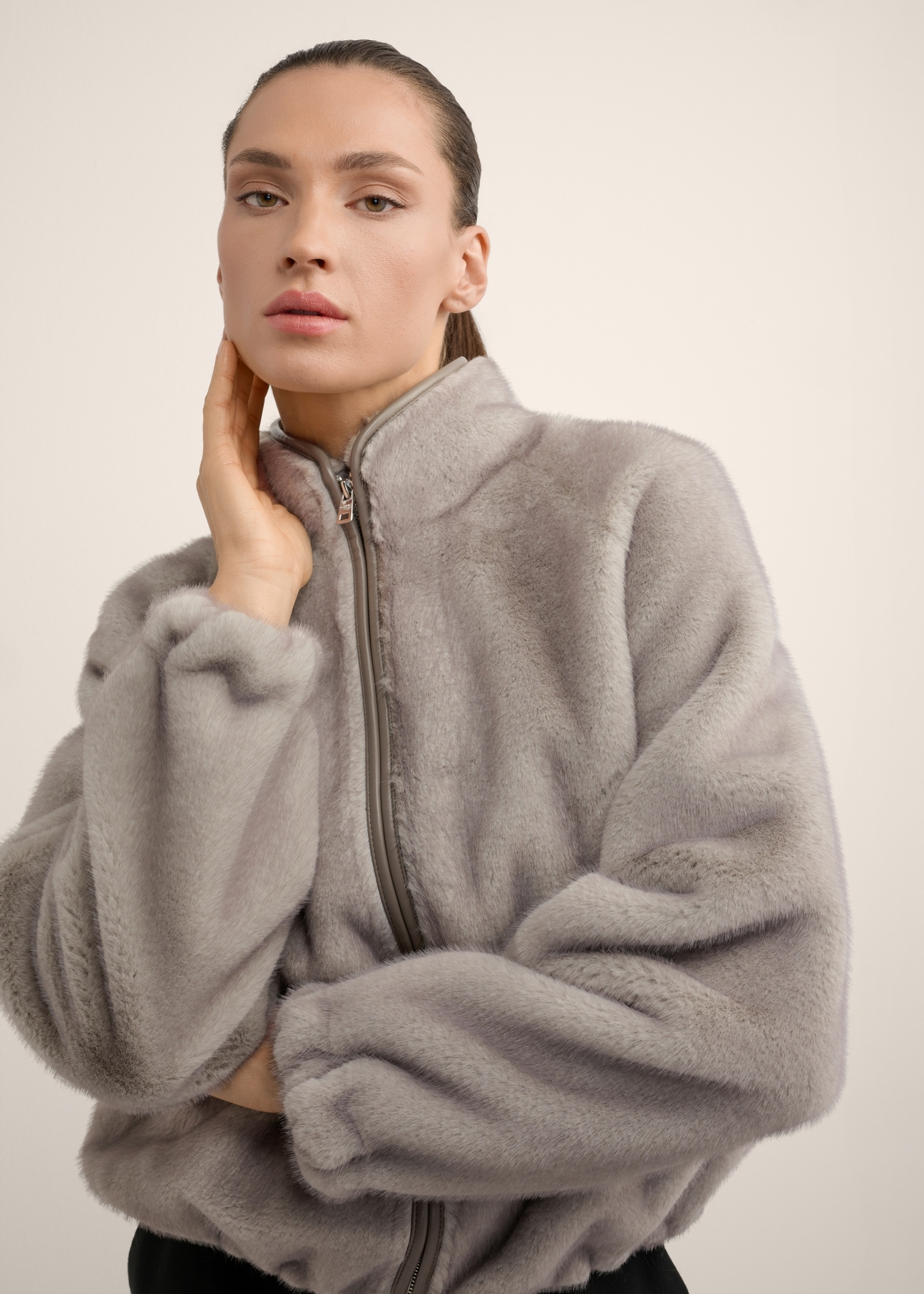 Short gray women's fur coat FUTDP-0083-9B(Z26) front view of the product on the model, half of the silhouette visible.-02