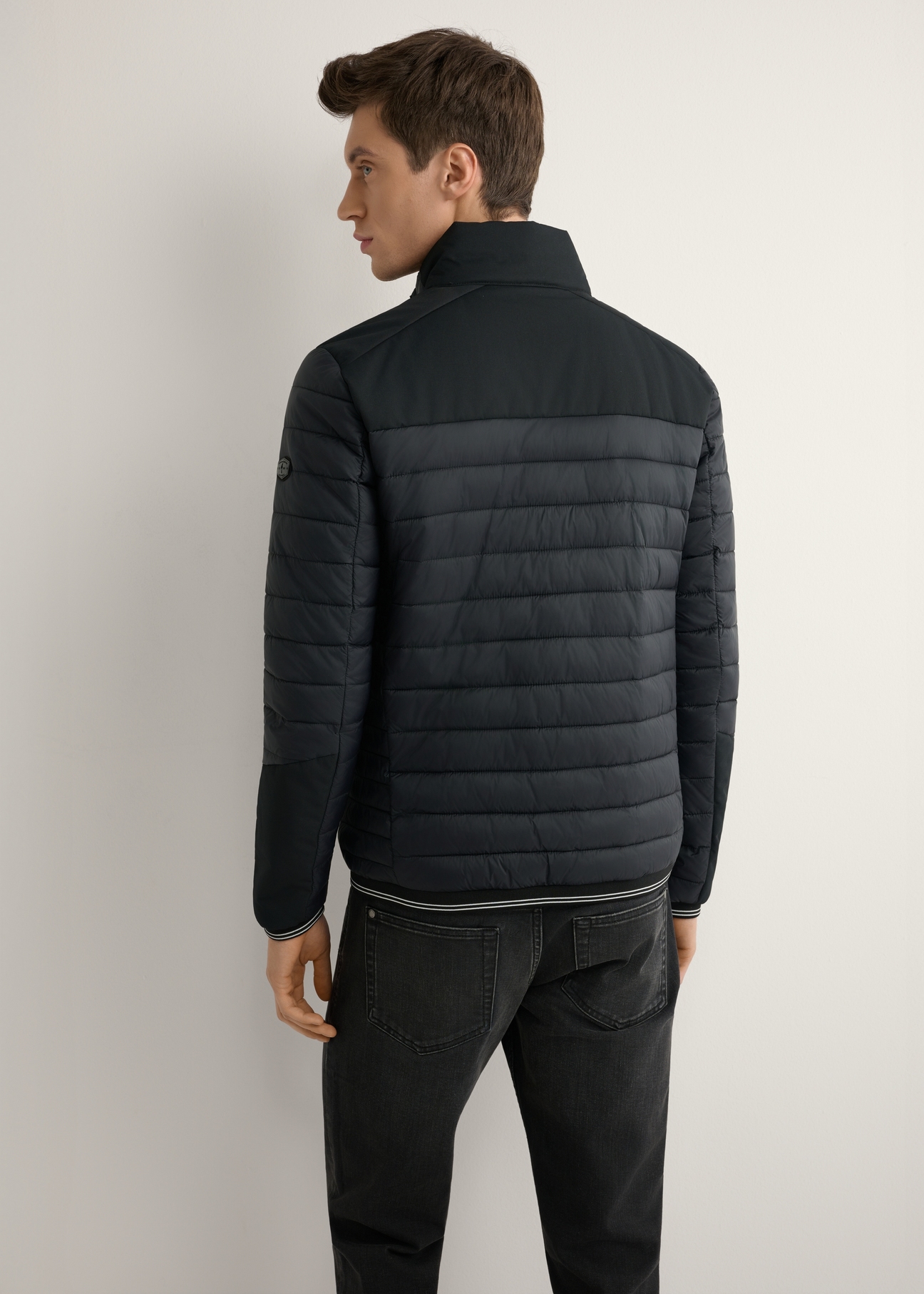 Men's black transitional jacket KURMT-0358A-99(W26) - rear view of the product on a model, against a light background. Half of the silhouette visible.