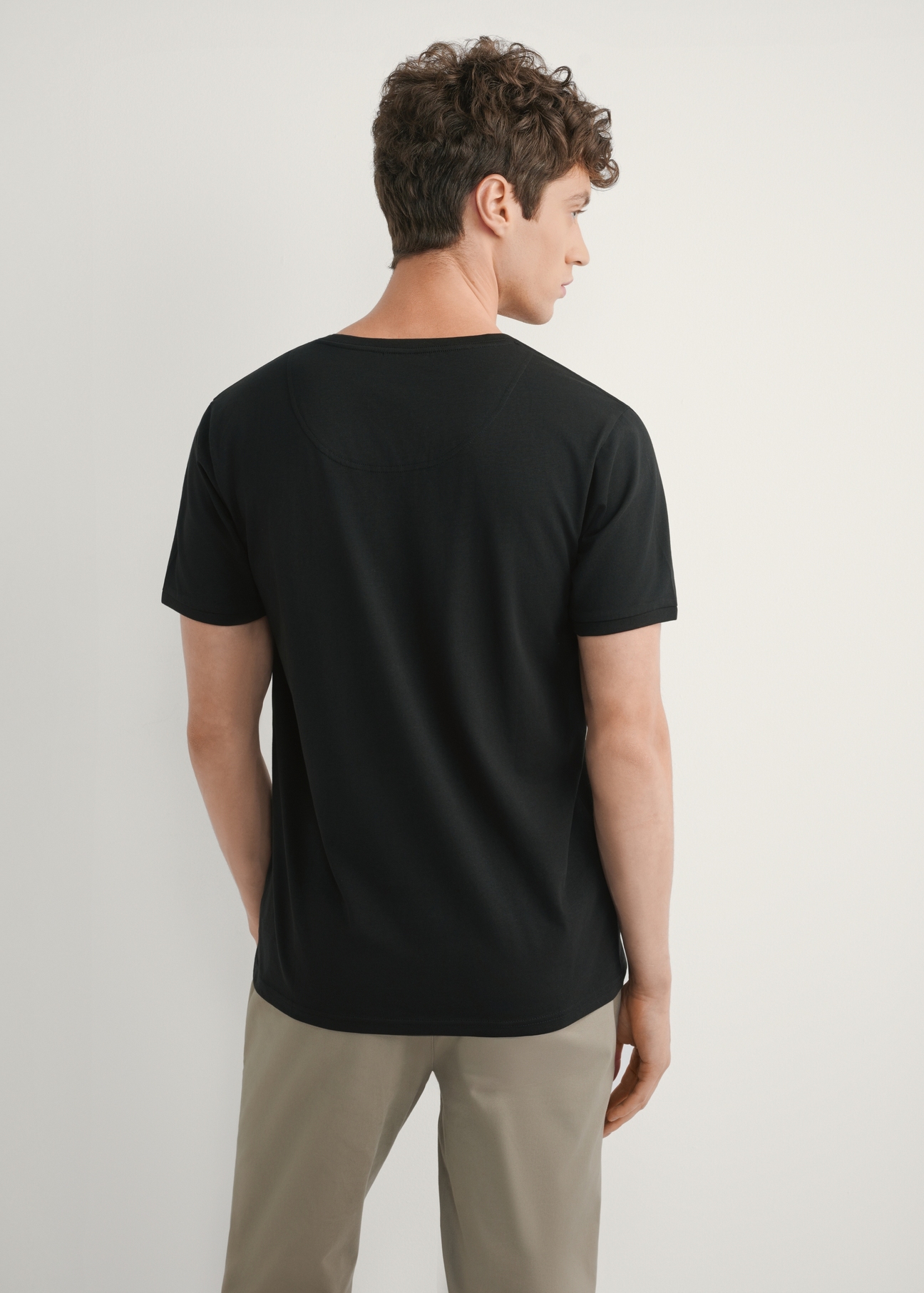 Black basic men's T-shirt with logo TSHMT-0088-99(W25), product view from the back on the model, half of the silhouette visible.