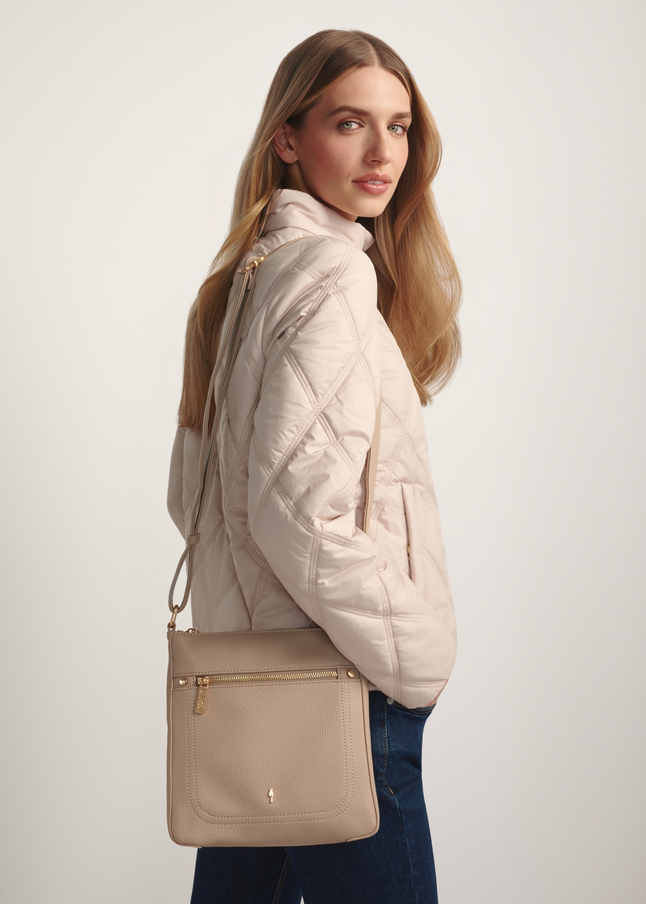 Beige women's imitation leather messenger bag TOREC-1177-1B(W26) - front view of the product, on a model, against a light background. Half of the silhouette visible.