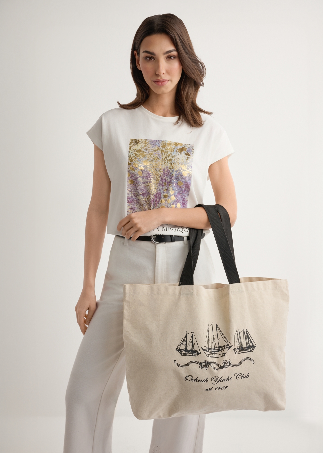 Cream cotton tote bag with print TOREN-0136-0P(W26), product view on model's shoulder. Half of silhouette visible.