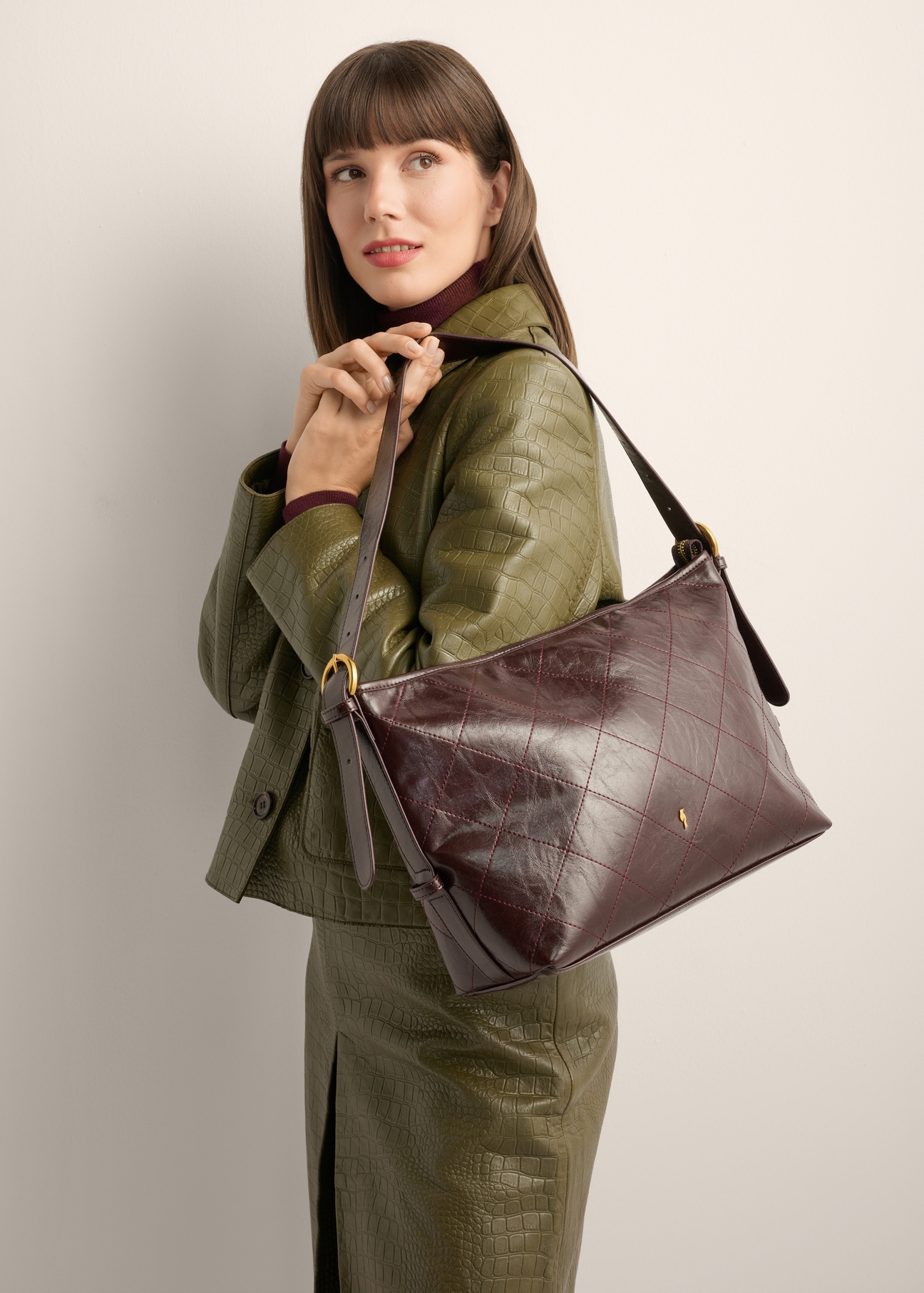 Burgundy women's shoulder bag with stitching TOREC-1248-4D(Z26), product view on model's shoulder. Half of silhouette visible.