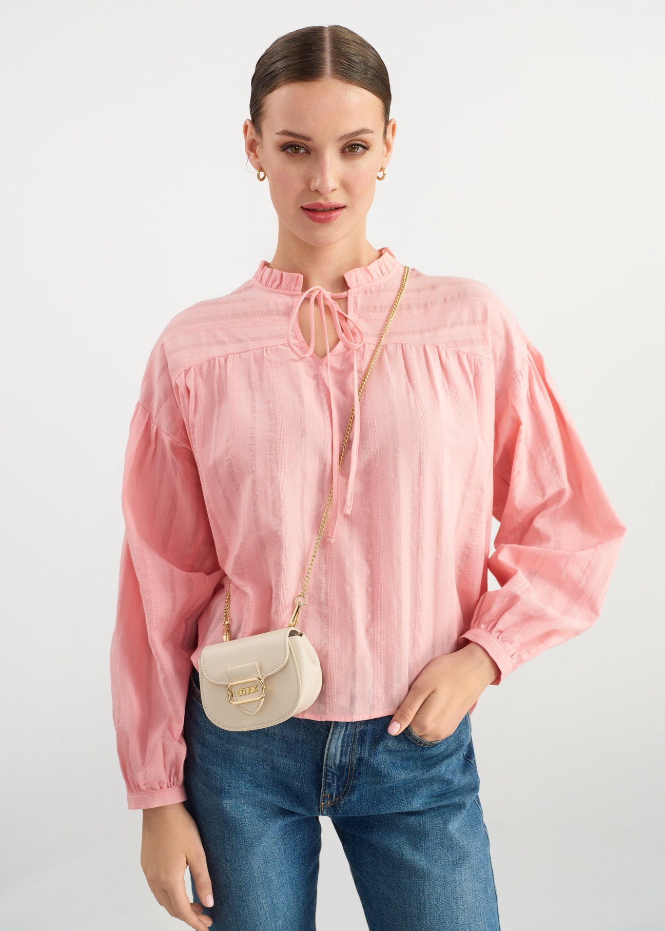 Small cream handbag on a chain TOREC-1013-12(W25) - front view on a model on a white background. Half of the silhouette visible.