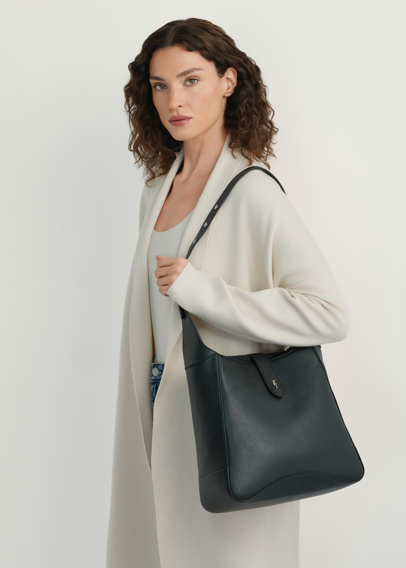 Black medium leather shoulder bag TORES-1210-9I(W26), product view on model's shoulder. Half silhouette visible.