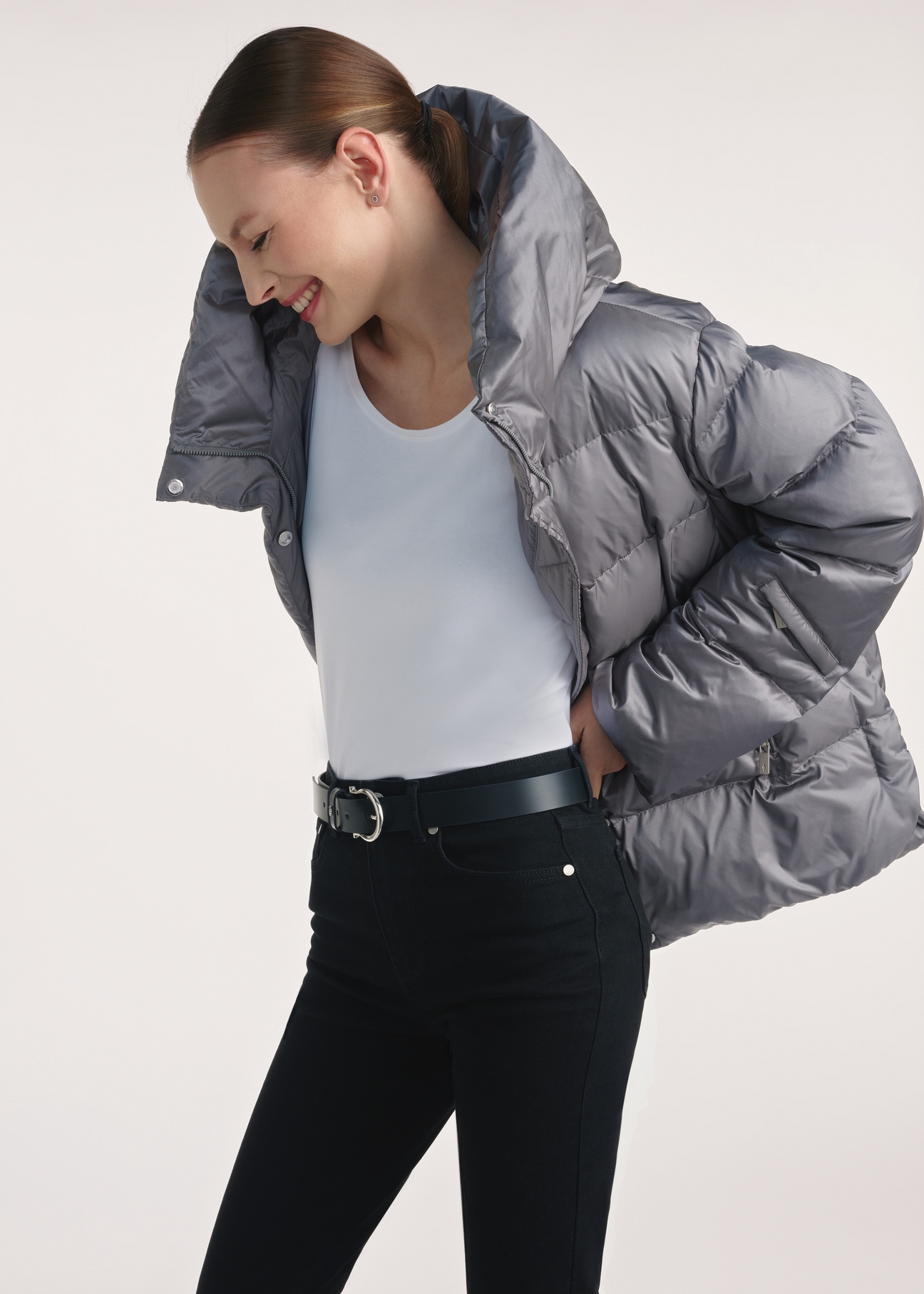 Gray women's down jacket KURDT-0585-91(Z25), side view of the product on the model, half of the silhouette visible.