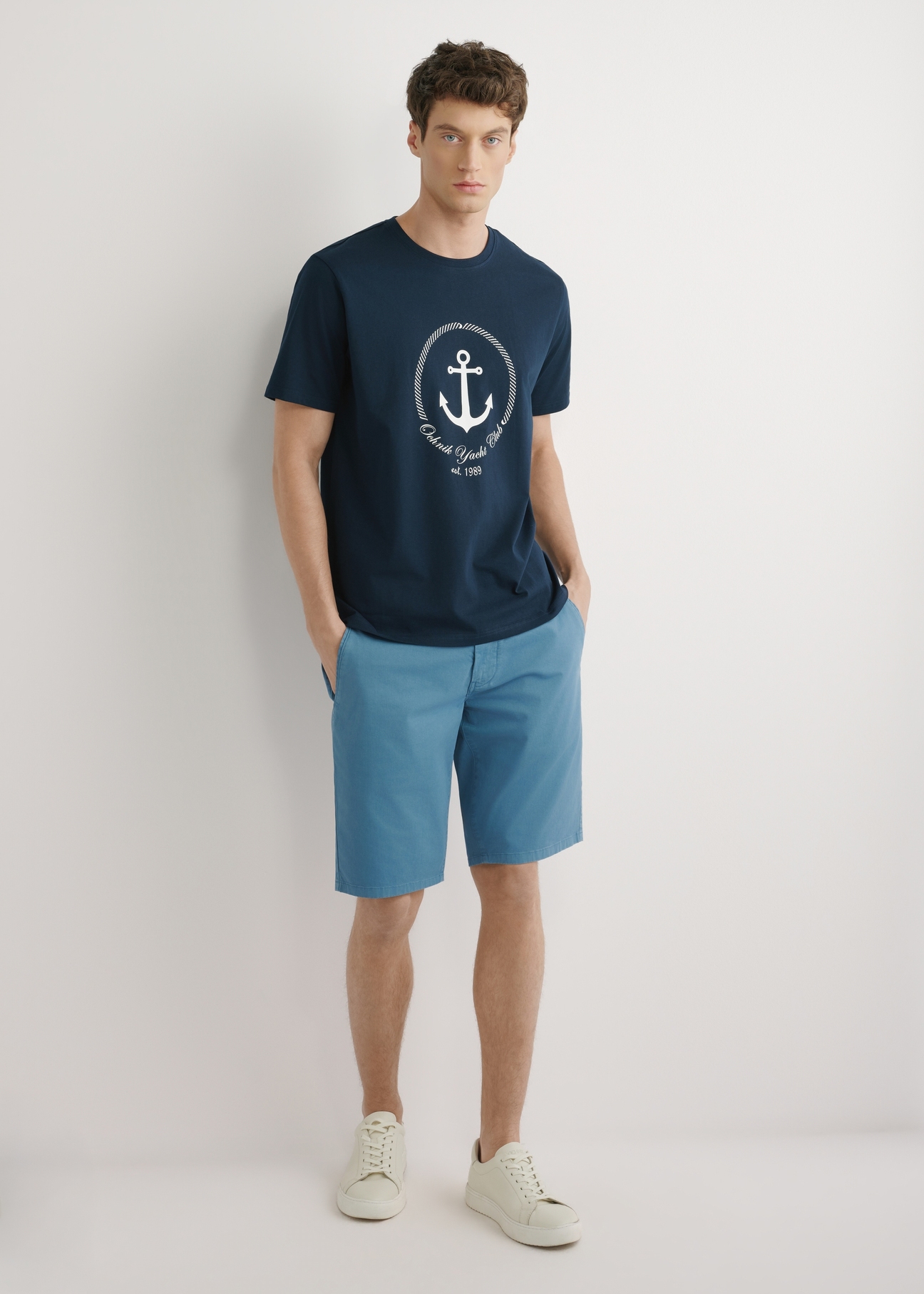 Navy blue men's T-shirt with print TSHMT-0147-7E(W26), front view of the product, on a model, against a light background. Full body visible.