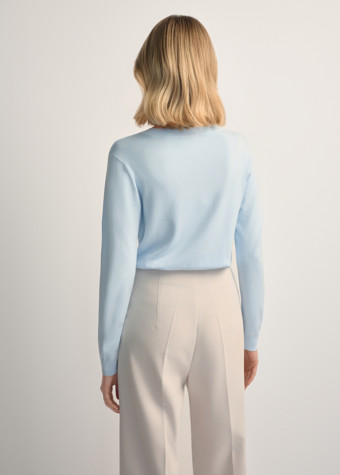 Light blue V-neck sweater SWEDT-0201-7A(W26) - back view of the product, on a model, against a light background. Half of the silhouette visible.