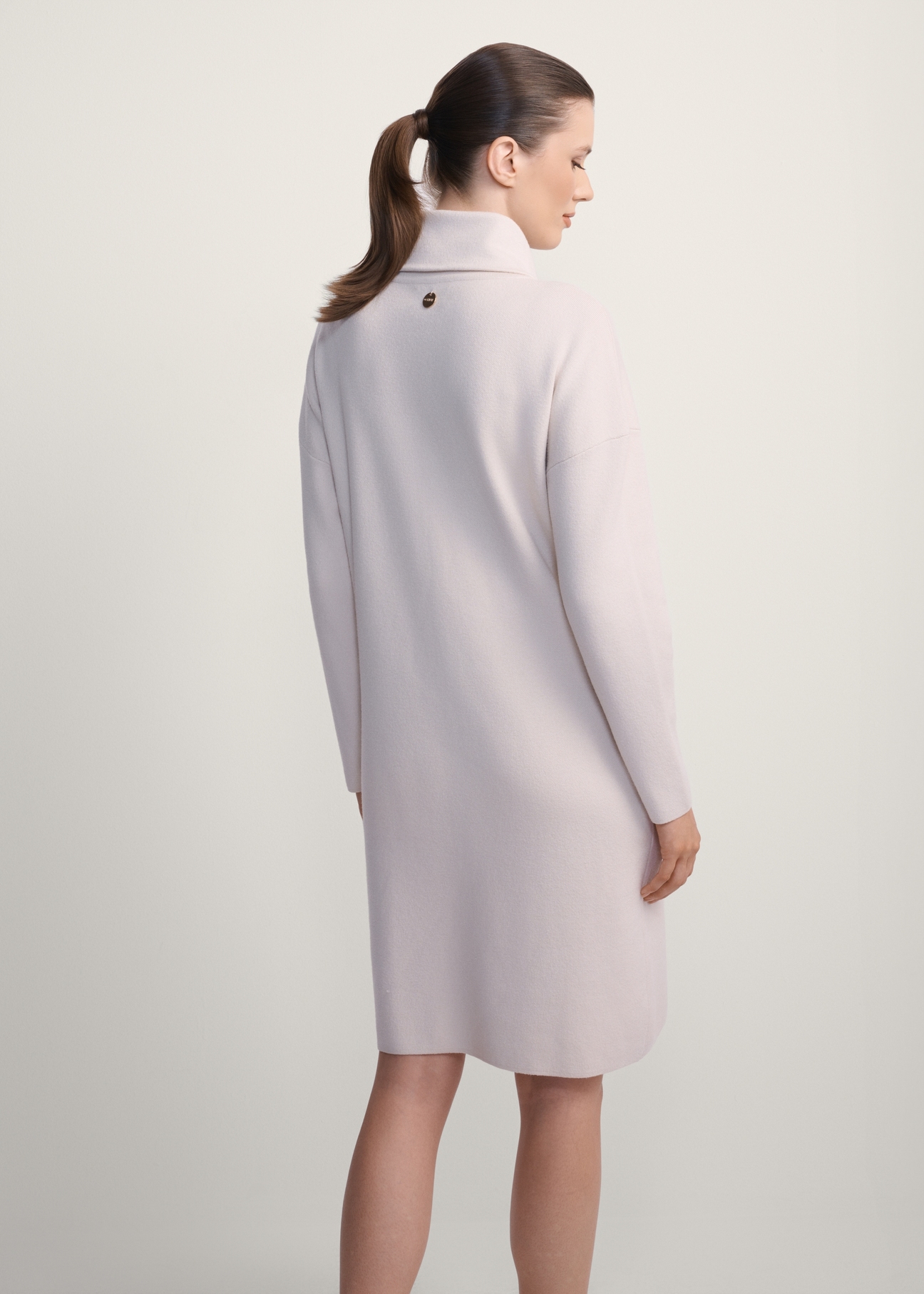 Beige turtleneck dress SUKDT-0206A-80(Z25), product view from the back on the model, half of the silhouette visible.