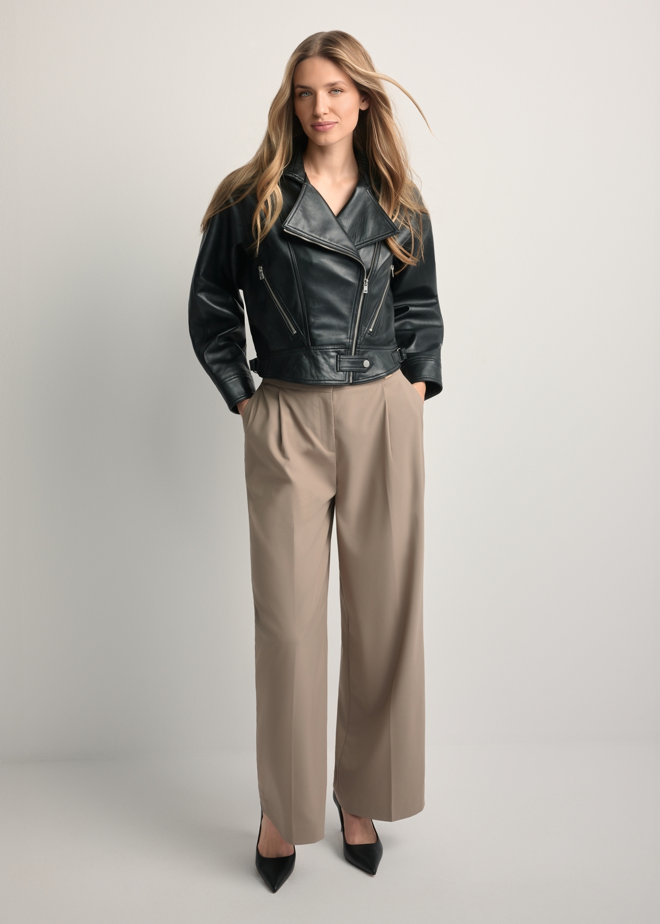 Women's short black leather jacket KURDS-0607-99(W26) - front view of the product on a model, against a light background. Full body visible.