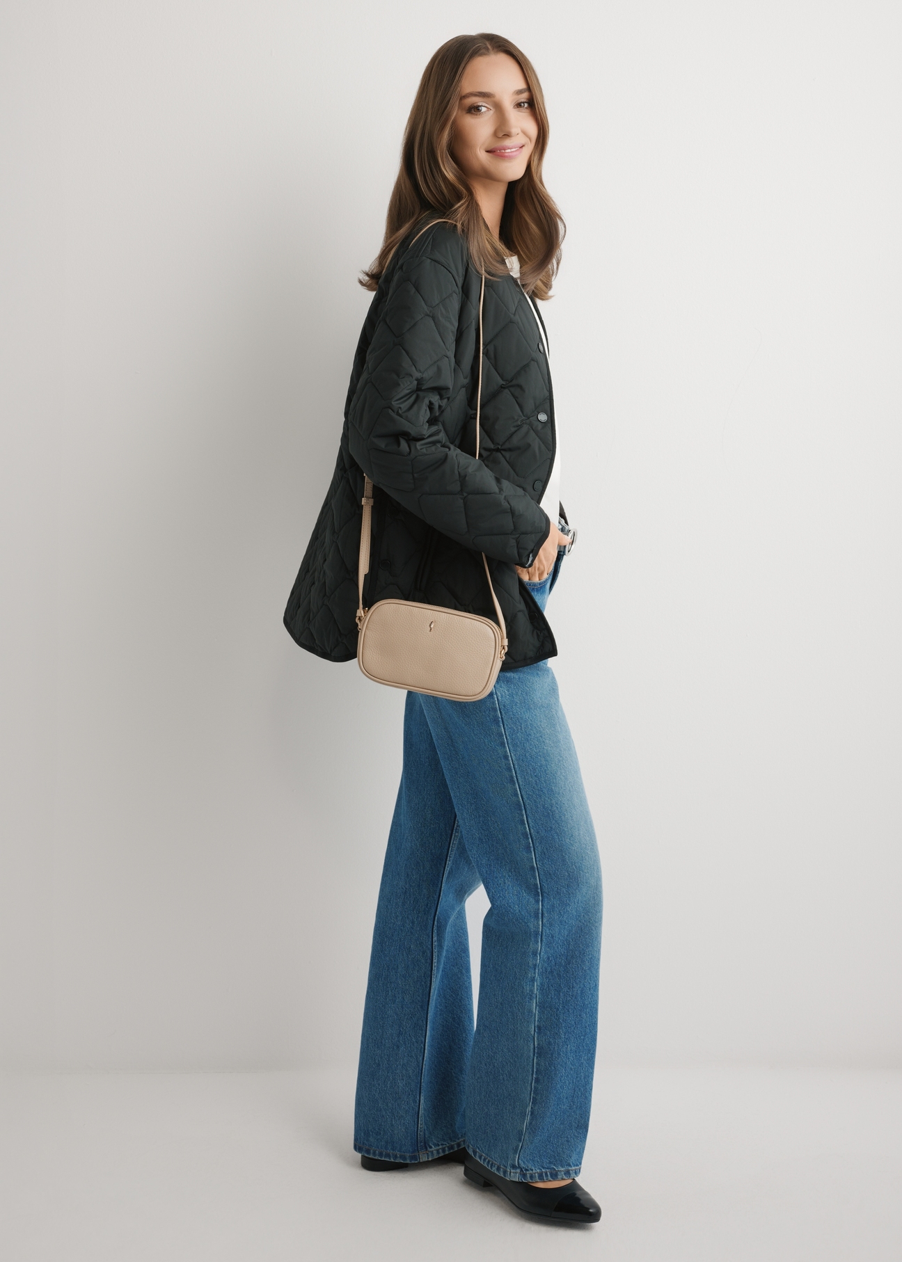 Small beige leather women's handbag TORES-0466E-1B(W26), front view of the product on a model, the whole silhouette is visible.