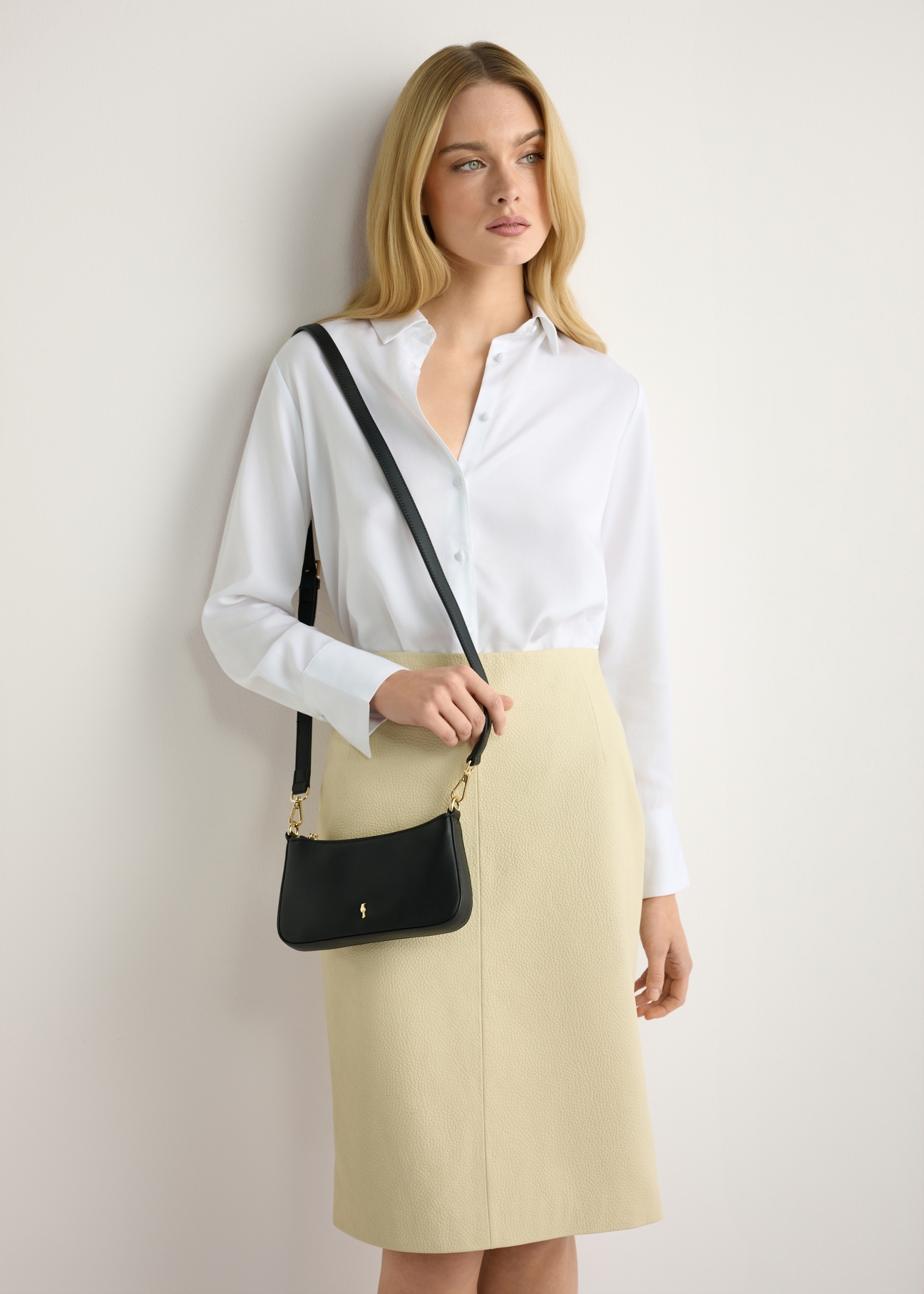 Small black women's handbag TOREC-1188-99(W26) - front view of the product, on a model, against a light background. Half-length silhouette visible.