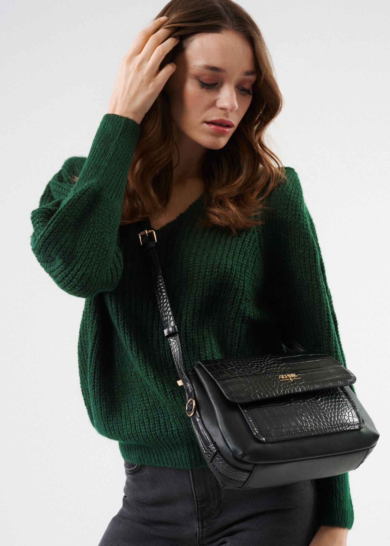 Women's handbag with croco elements TOREC-0860A-97(Z25), front view of the product on the model. Half of the silhouette visible.