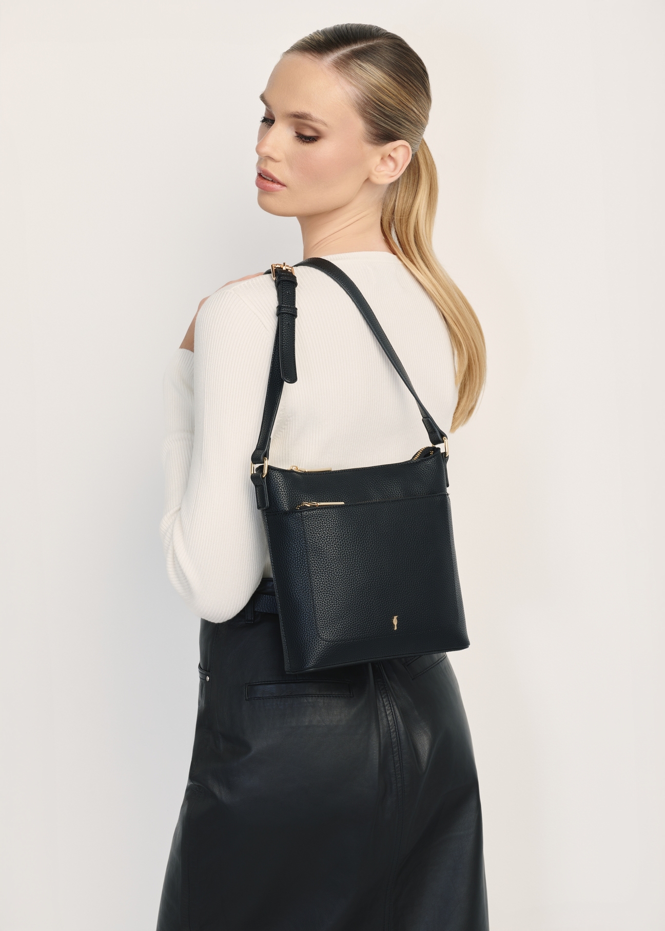 Black women's shoulder bag TOREC-1052-99(Z25), product view on a model, half of the silhouette visible.