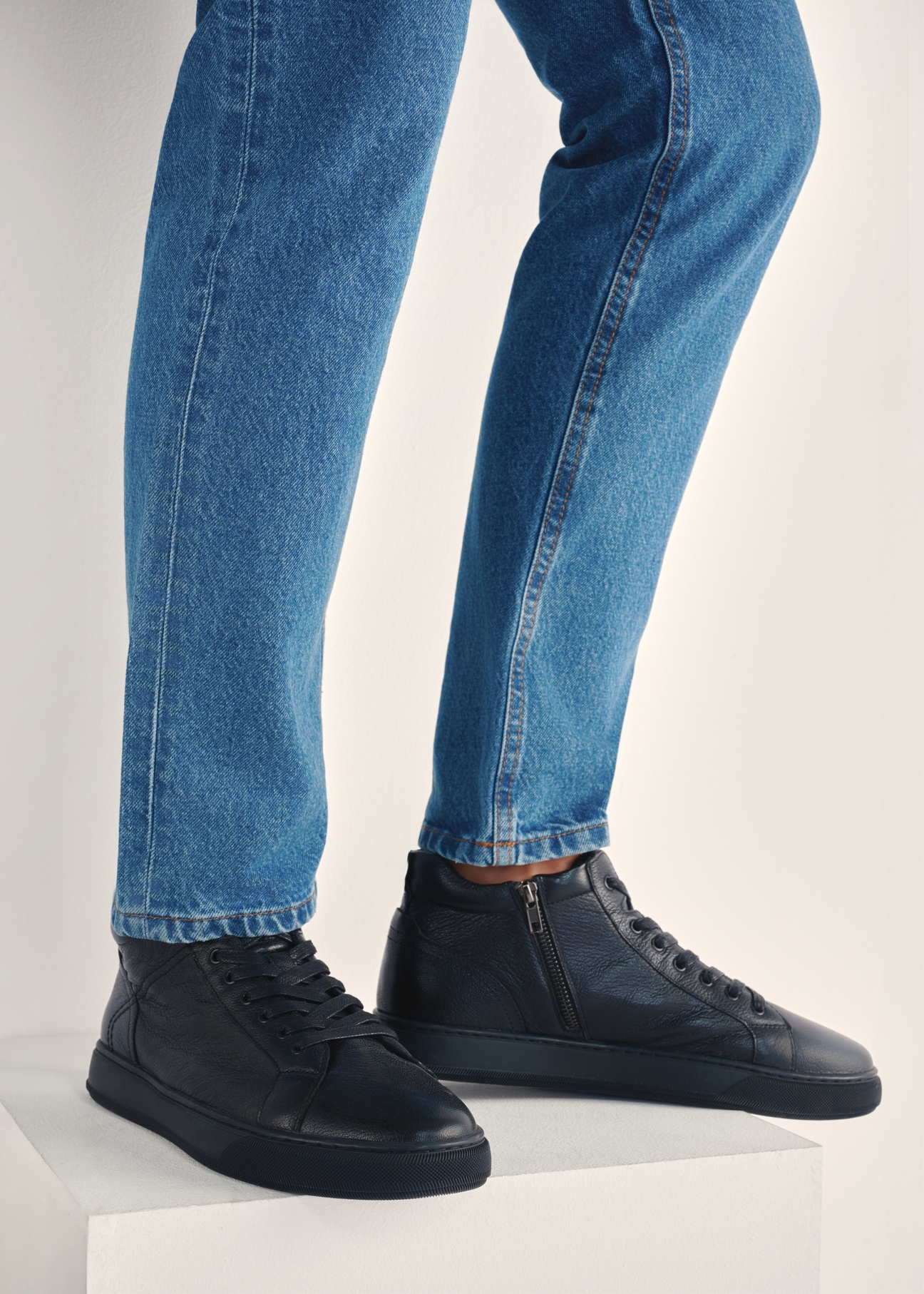 Black men's leather sneakers BUTYM-0466-99(Z25), product view on model's feet against a light background.