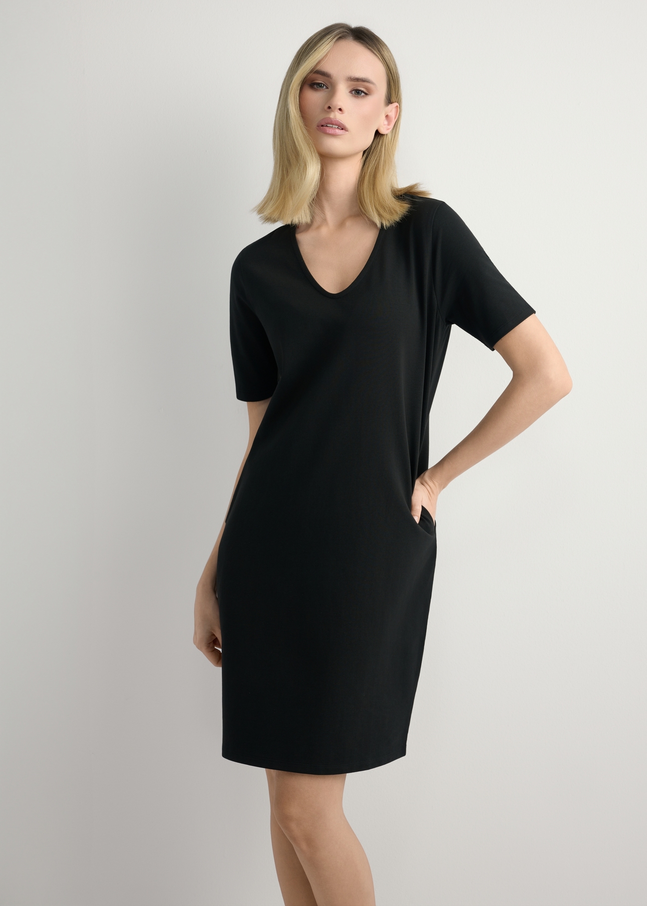 Black cotton dress SUKDT-0185A-99(W26), front view of the product on the model. Half of the silhouette visible.