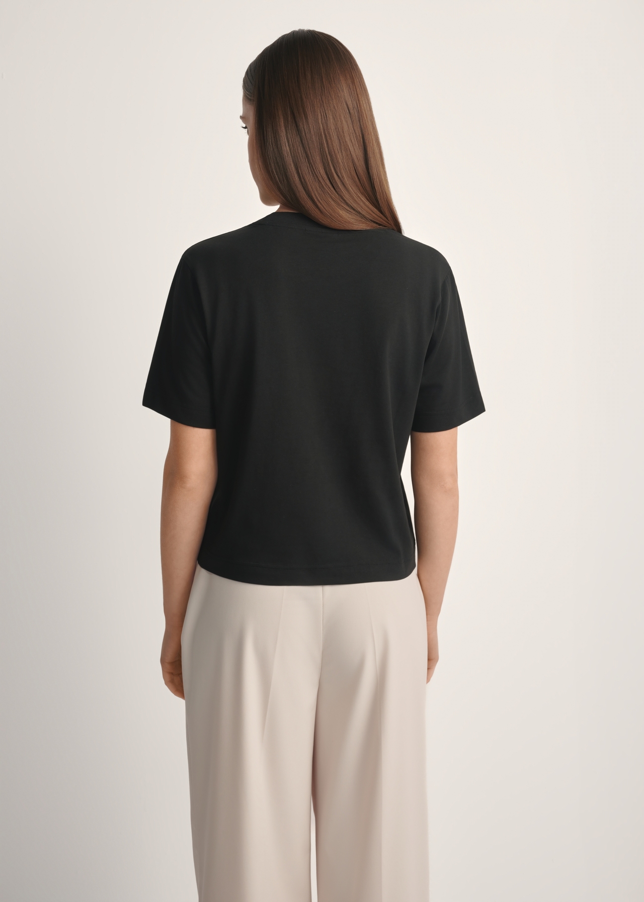 Women's cotton black T-shirt TSHDT-0138-99(W25), product view from the back on the model, half of the silhouette visible.