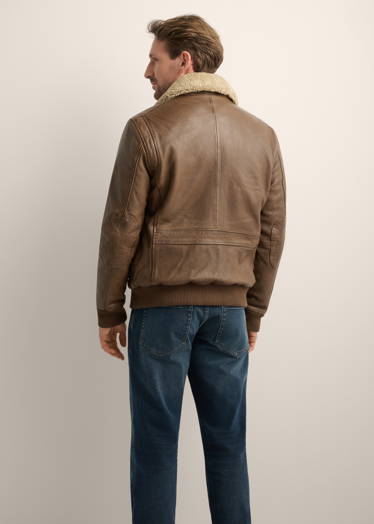 Men's brown leather bomber jacket KURMS-0424-1K(Z26), product view from the back on the model. Half of the silhouette visible.