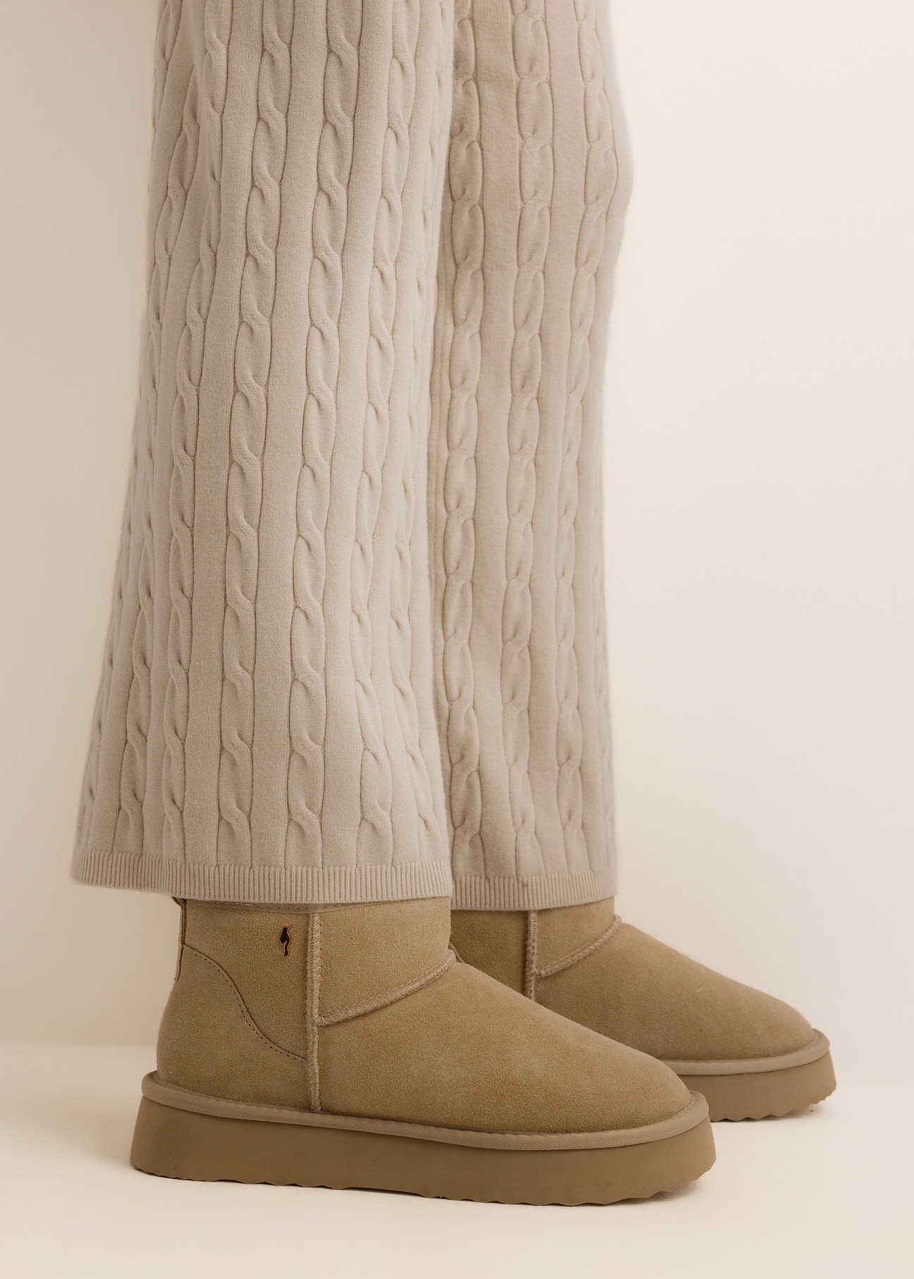 Beige short women's snow boots (BUTYD-1138-1K(Z26)), side view on a model's feet, against a light background.