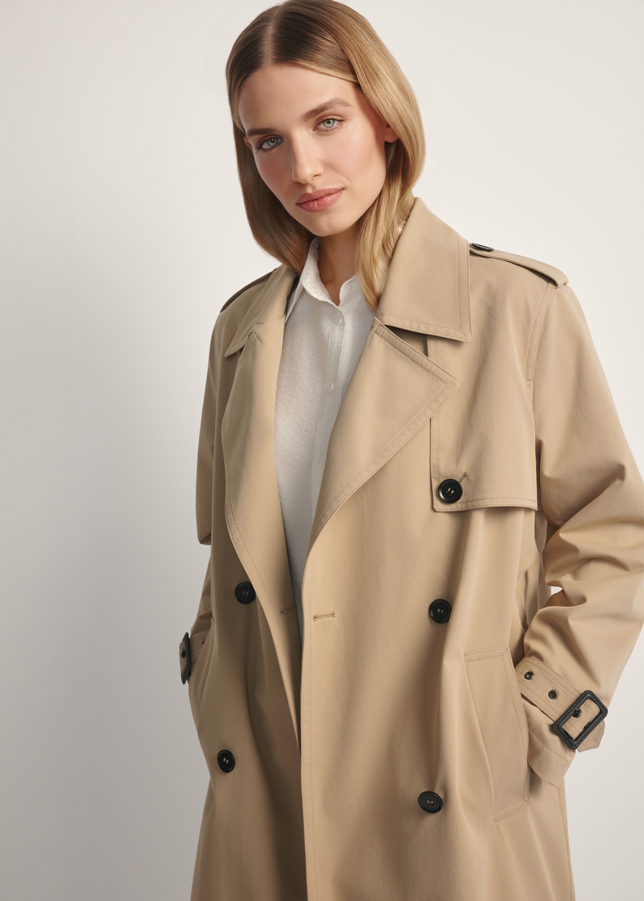 Long beige women's coat KURDT-0512-1C(W26), close-up of the product detail on the model.