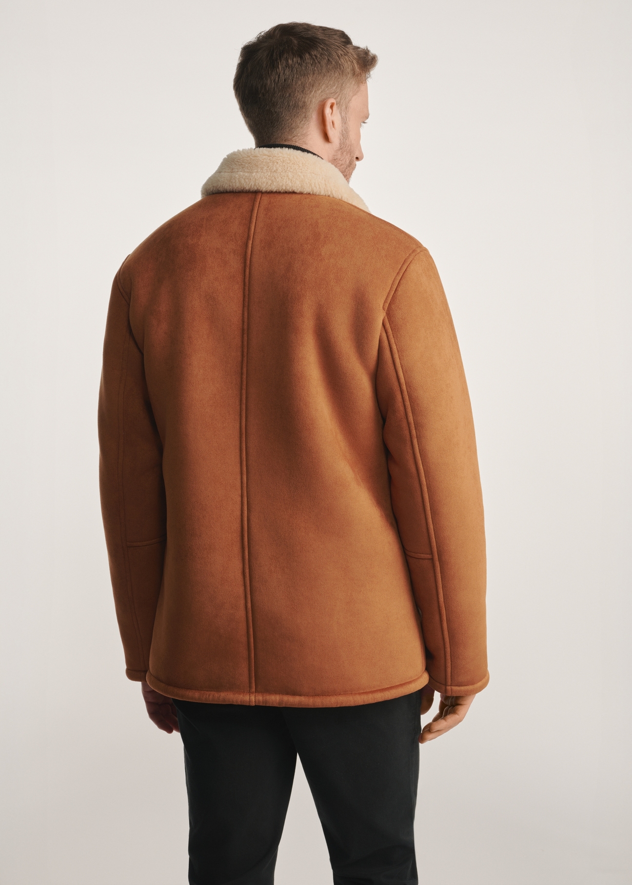 Men's sheepskin coat in camel color KOZMP-0010-24(Z25) - product view from the back on the model on a white background. Half of the silhouette visible.