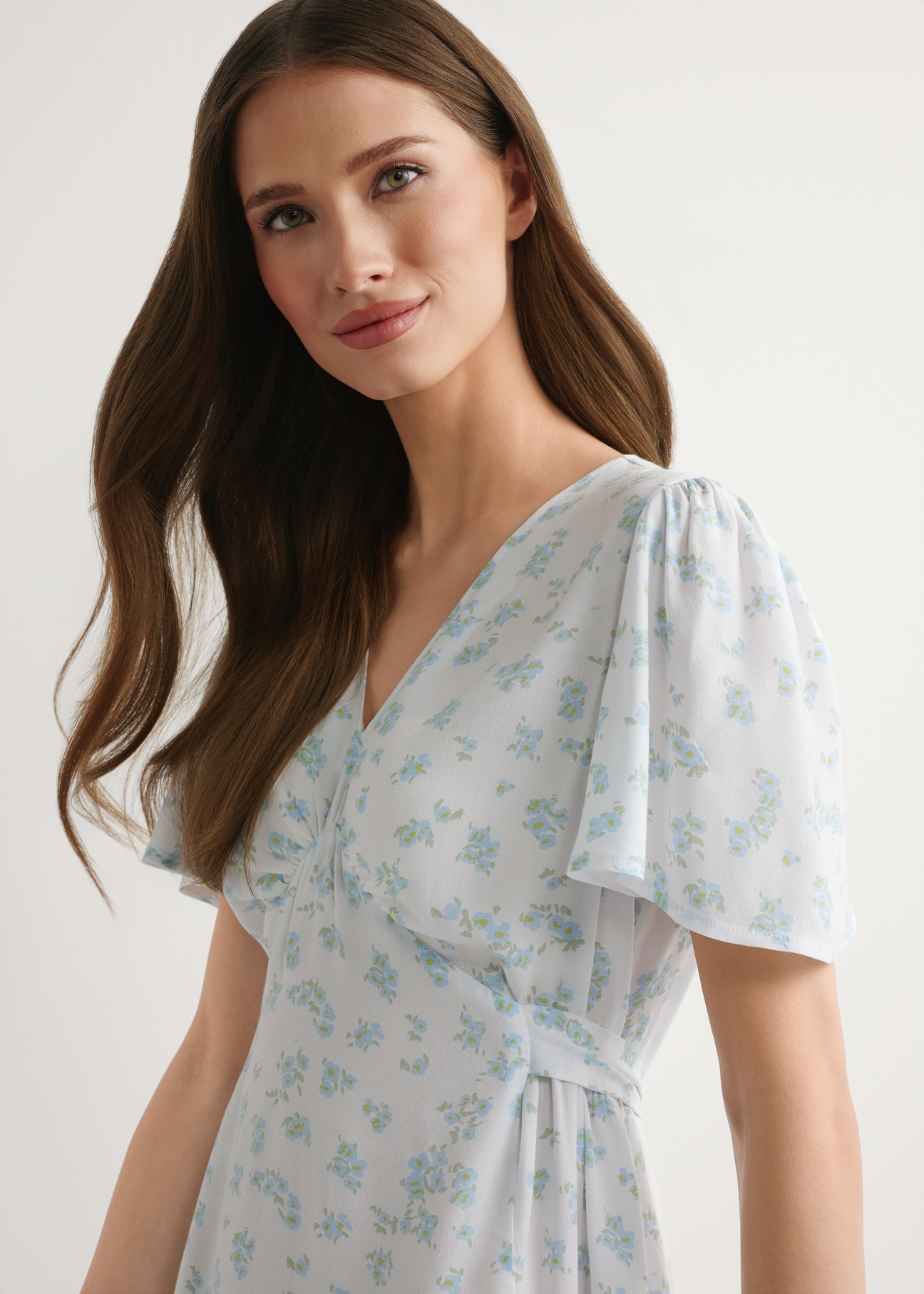 Women's short floral dress SUKDT-0276-7P(W26), front view of the product on the model. Half of the silhouette visible.