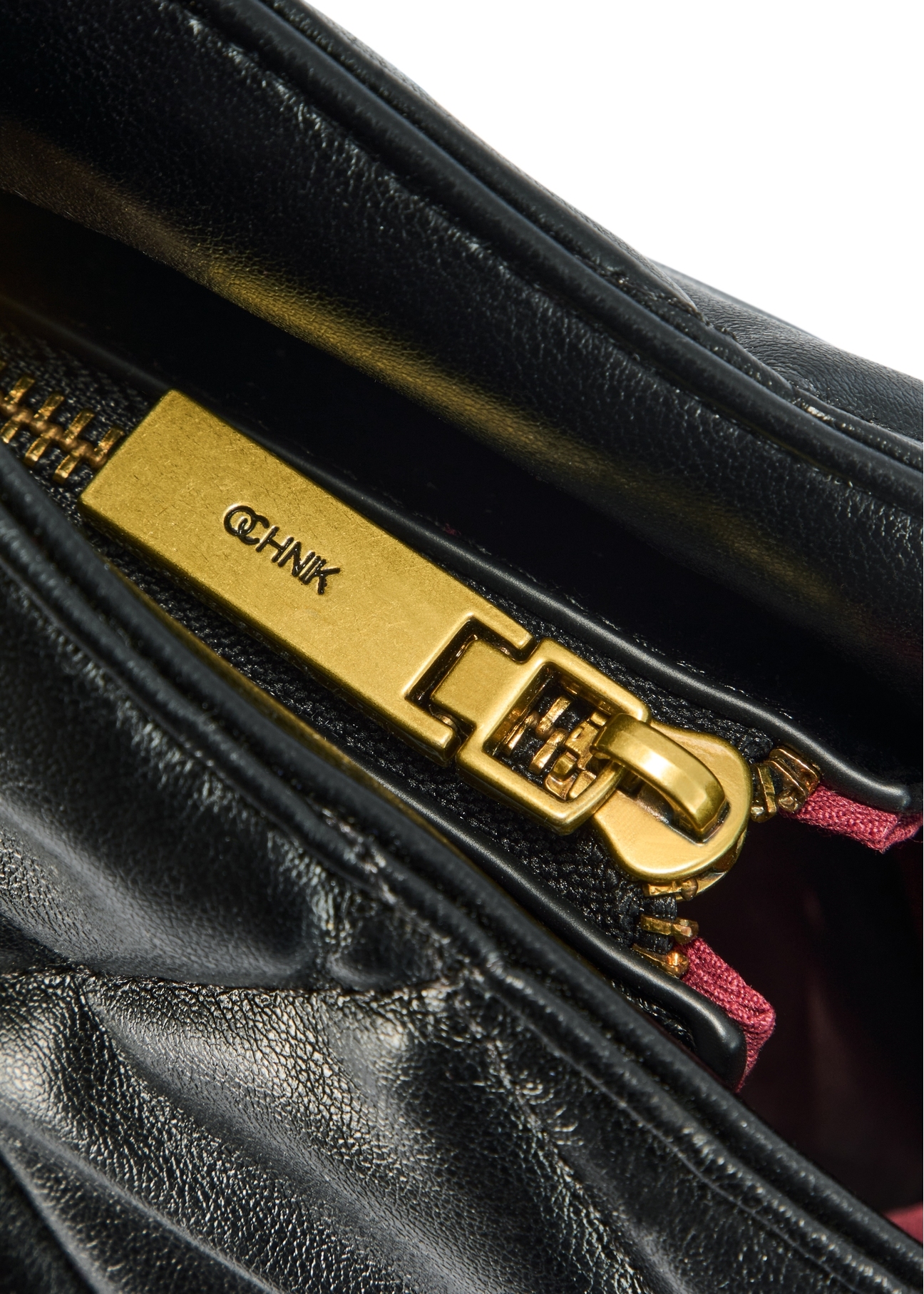 Black quilted women's handbag TOREC-1057-99(Z25), close-up of the product zipper, view on a white background.