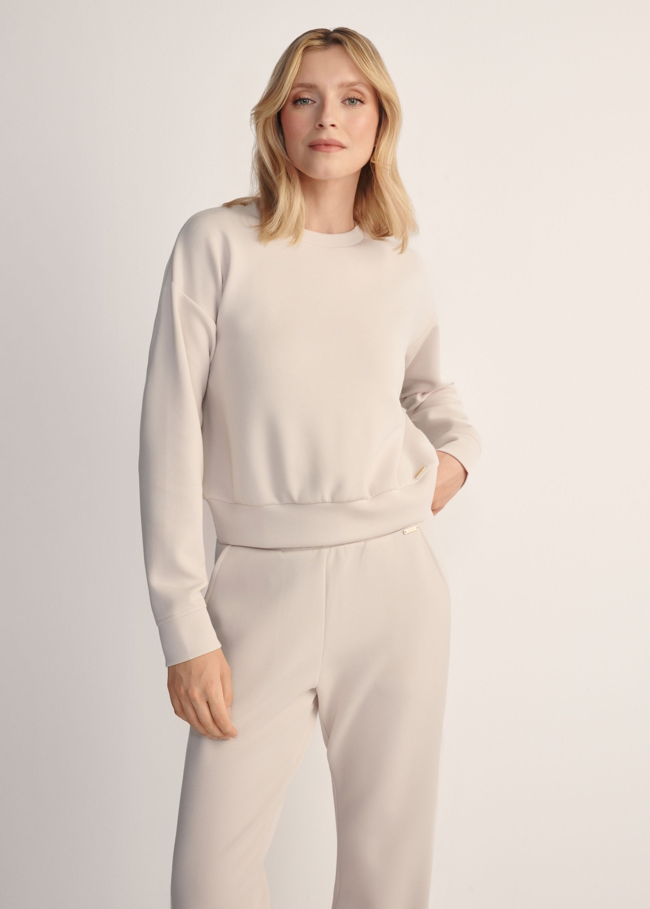 Light beige women's sweatshirt BLZDT-0119-1A(Z26), front view of the product on the model. Half of the silhouette visible.