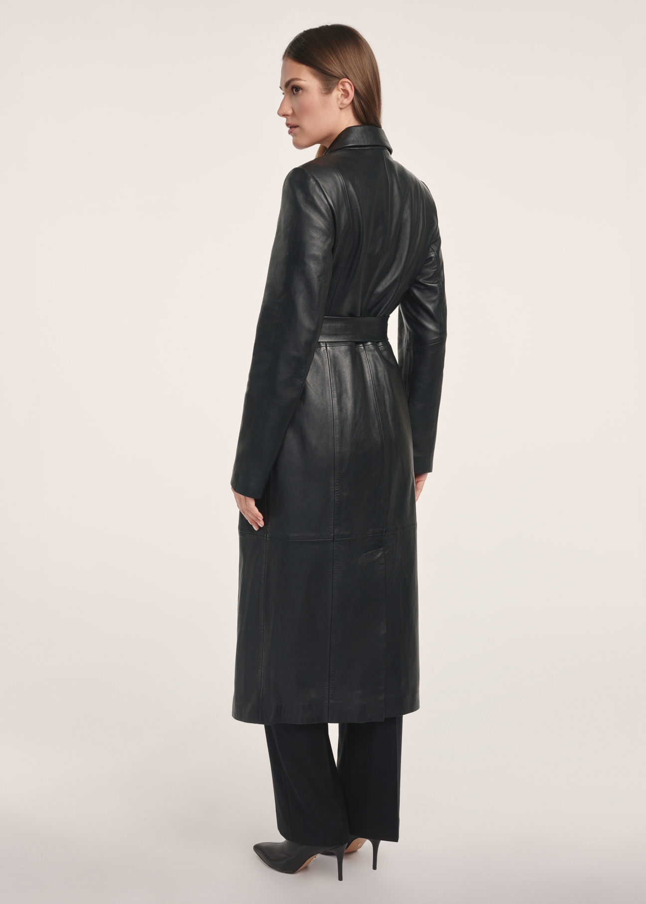 Black women's leather coat KURDS-0546-5344(Z25), product visible from the back on the model, the entire silhouette is visible.