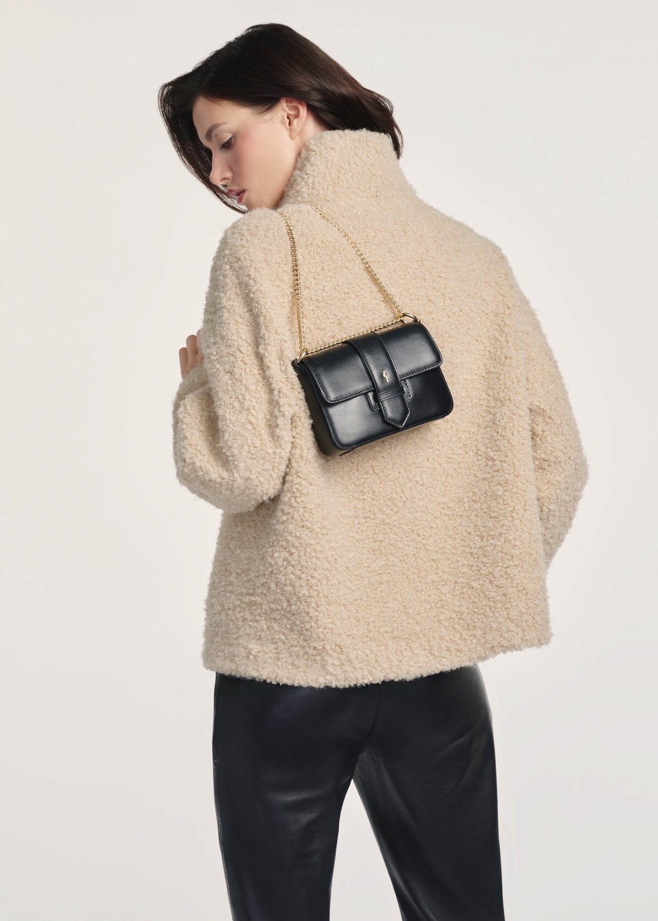 Black small leather handbag TORES-1150-99(Z25), product view on a model, half of the silhouette visible.