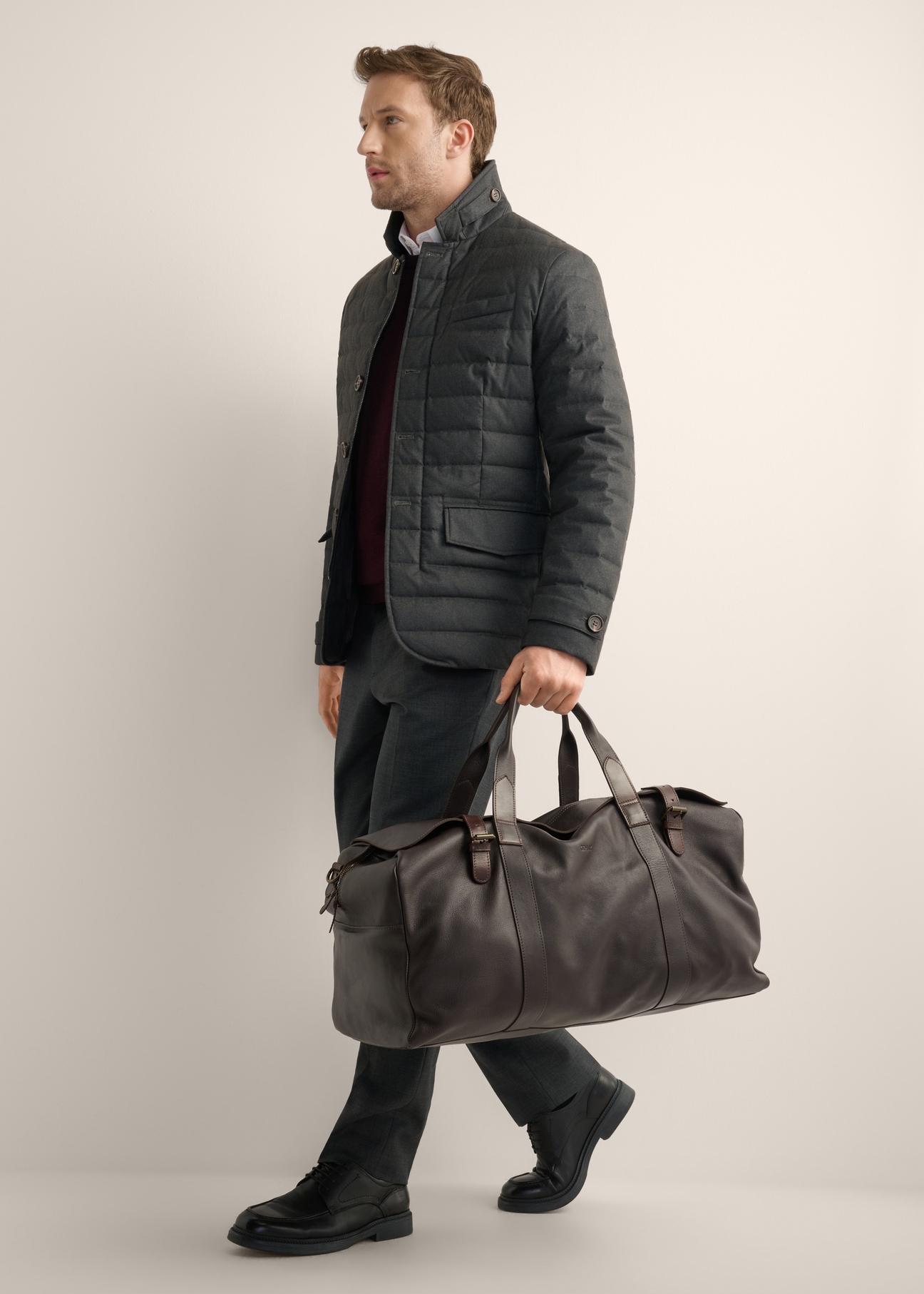 Brown leather travel bag TORMS-0520-1H(Z26), front view of the product in the model's hand.