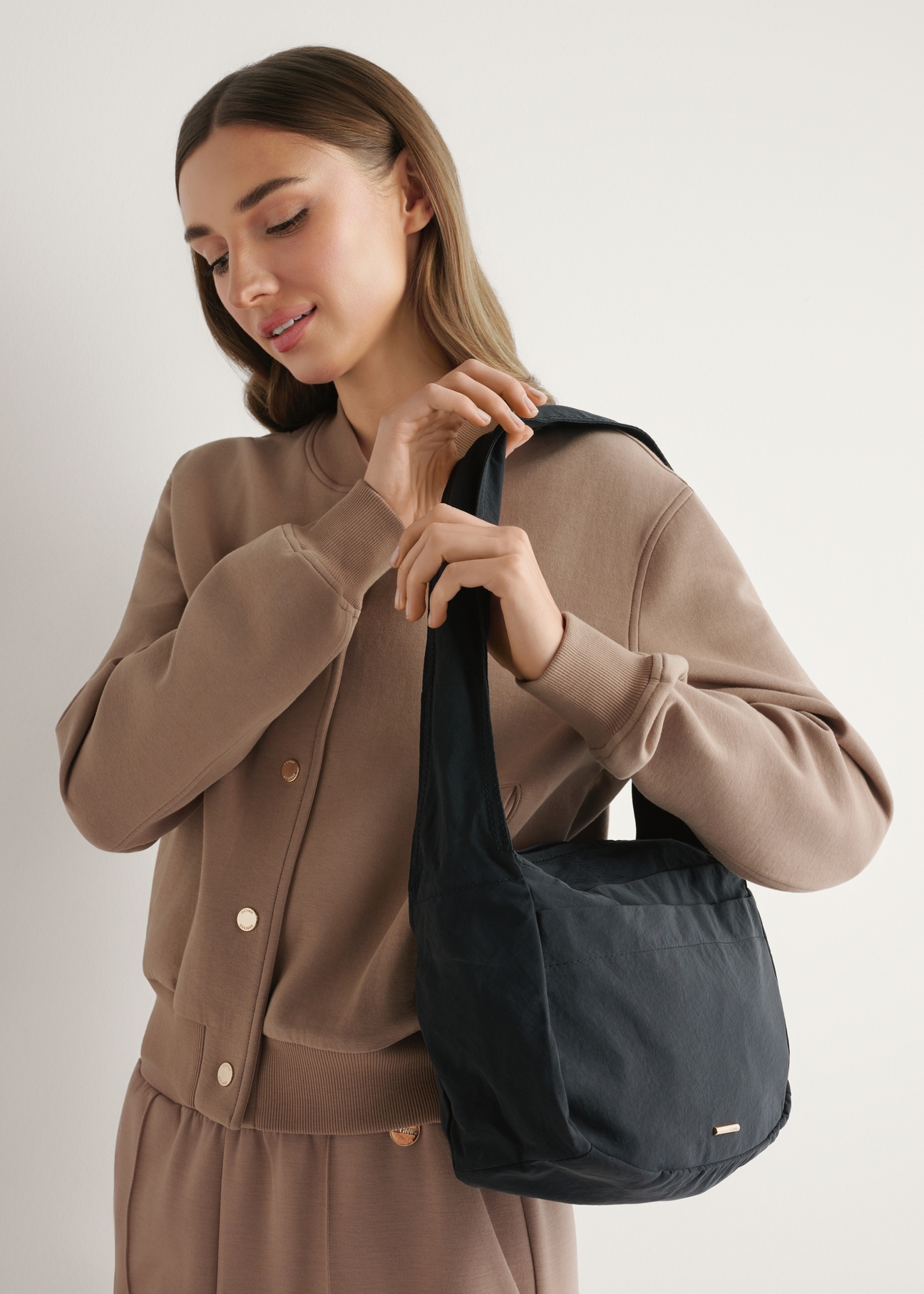 Black nylon women's handbag TOREN-0338-99(W26), diagonal view of the product on the model's shoulder.