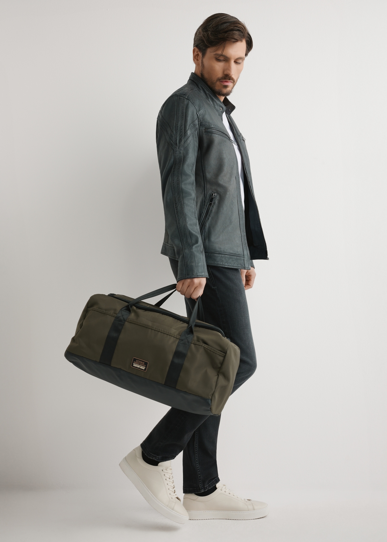 Khaki travel bag TORMN-0417-8D(W26) - front view of the product, held by the model, against a light background.