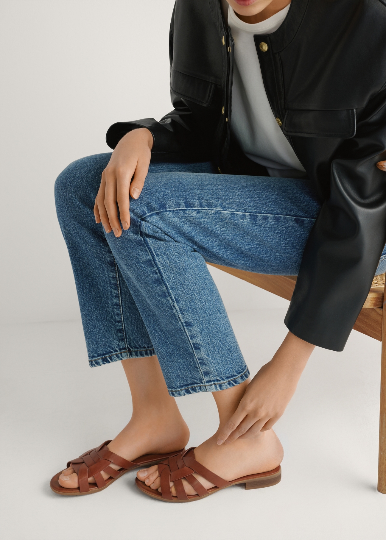 Women's leather mules in cognac color BUTYD-1266-1F(W26), side view of the product on the model's feet, on a light background.
