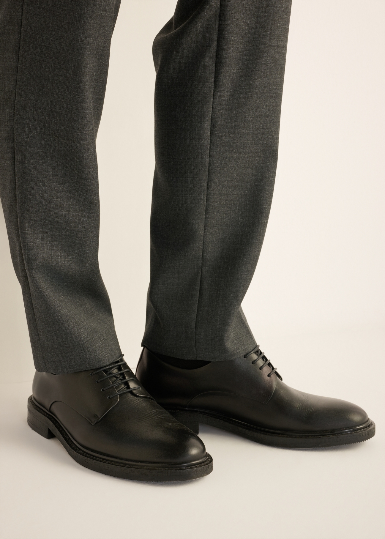 Black men's leather shoes BUTYM-0553-99(Z26) - side view of the product, on the model's feet, on a light background.