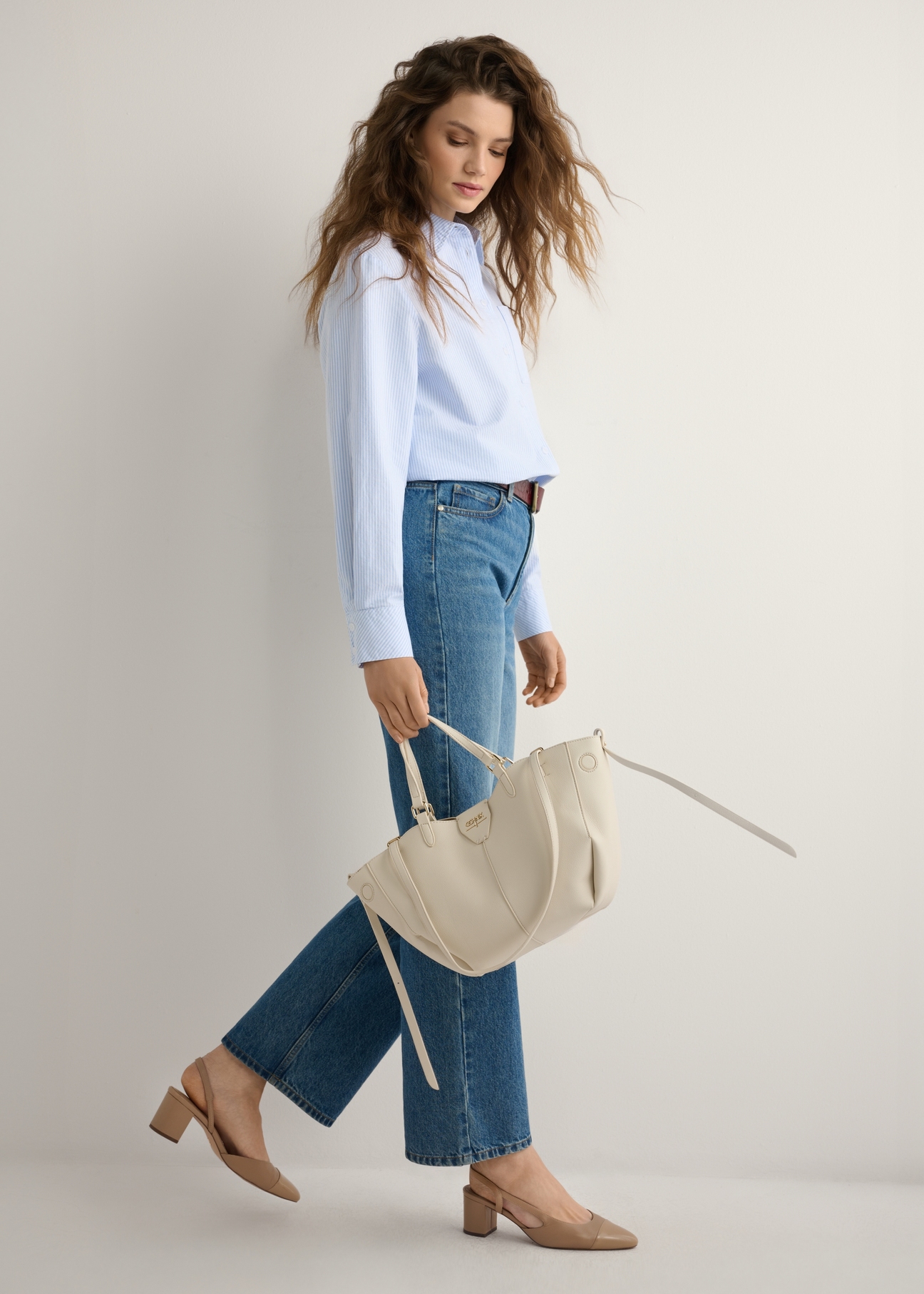 White women's shoulder bag TOREC-1231-0B(W26), product view in model's hand. Full body visible.