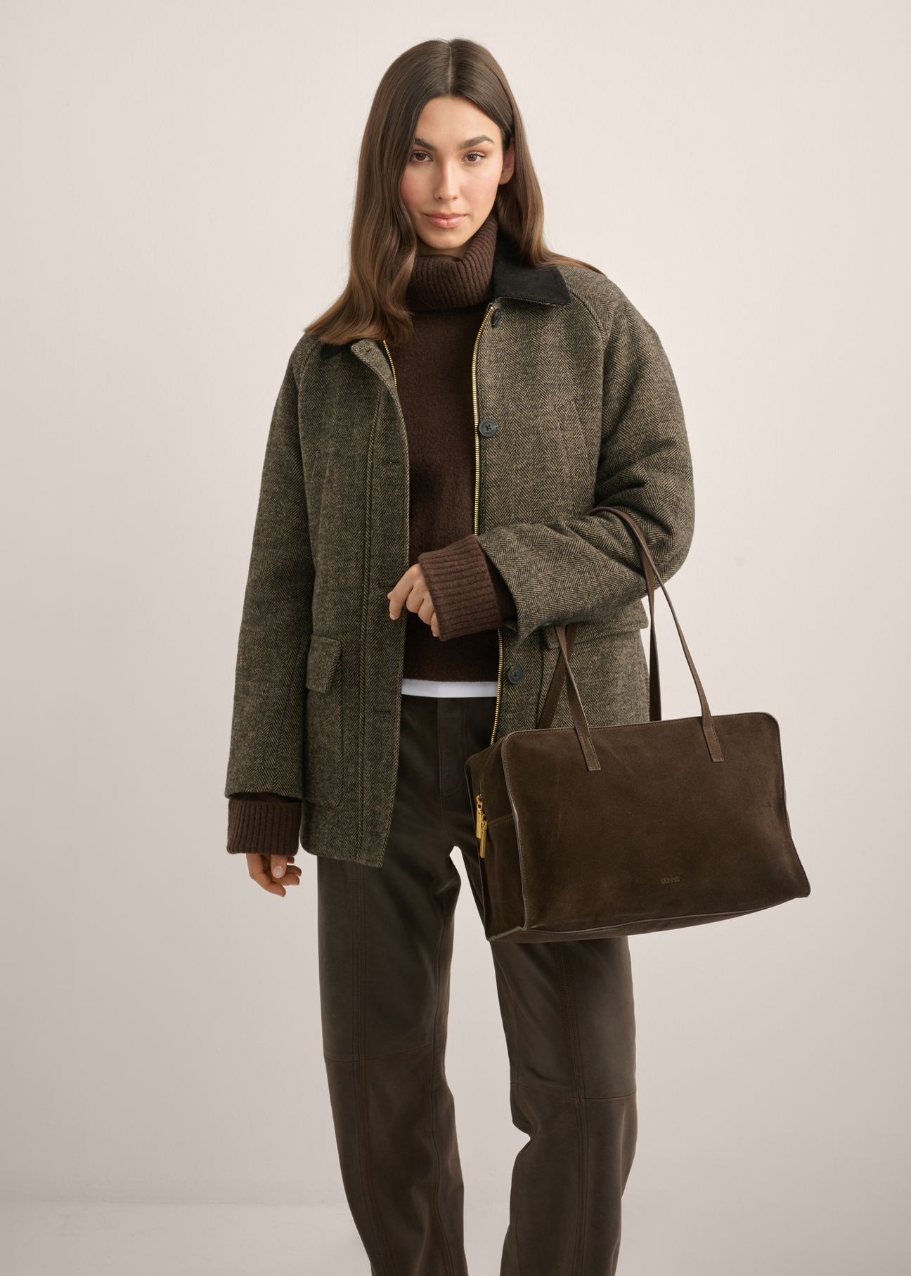 Women's brown suede shoulder bag TORES-1423-1I(Z26), front view of the product on a model. Half of the silhouette visible.