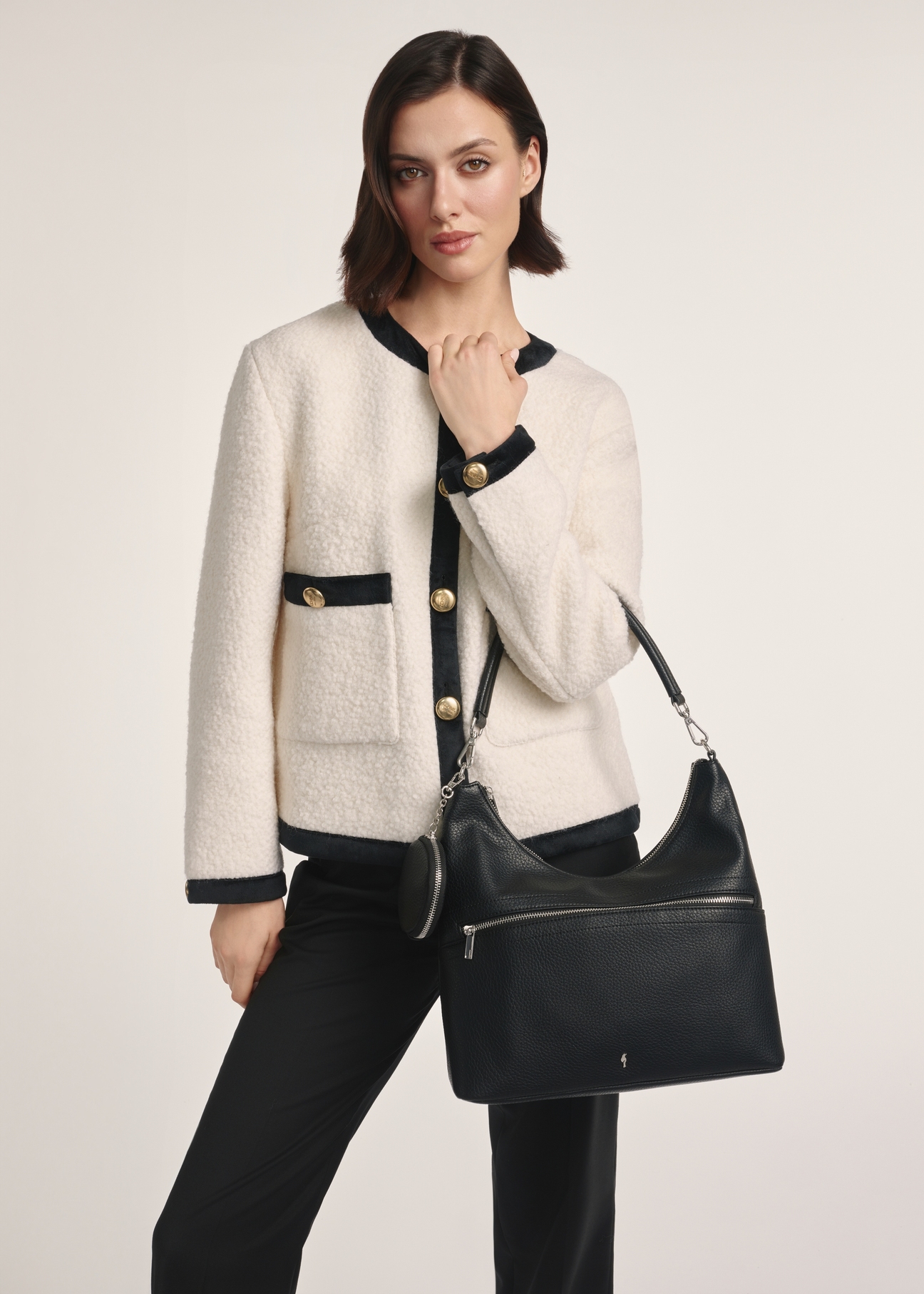 Black handbag with purse TOREC-0886A-99(Z25), front view of the product on a model, half of the silhouette visible.