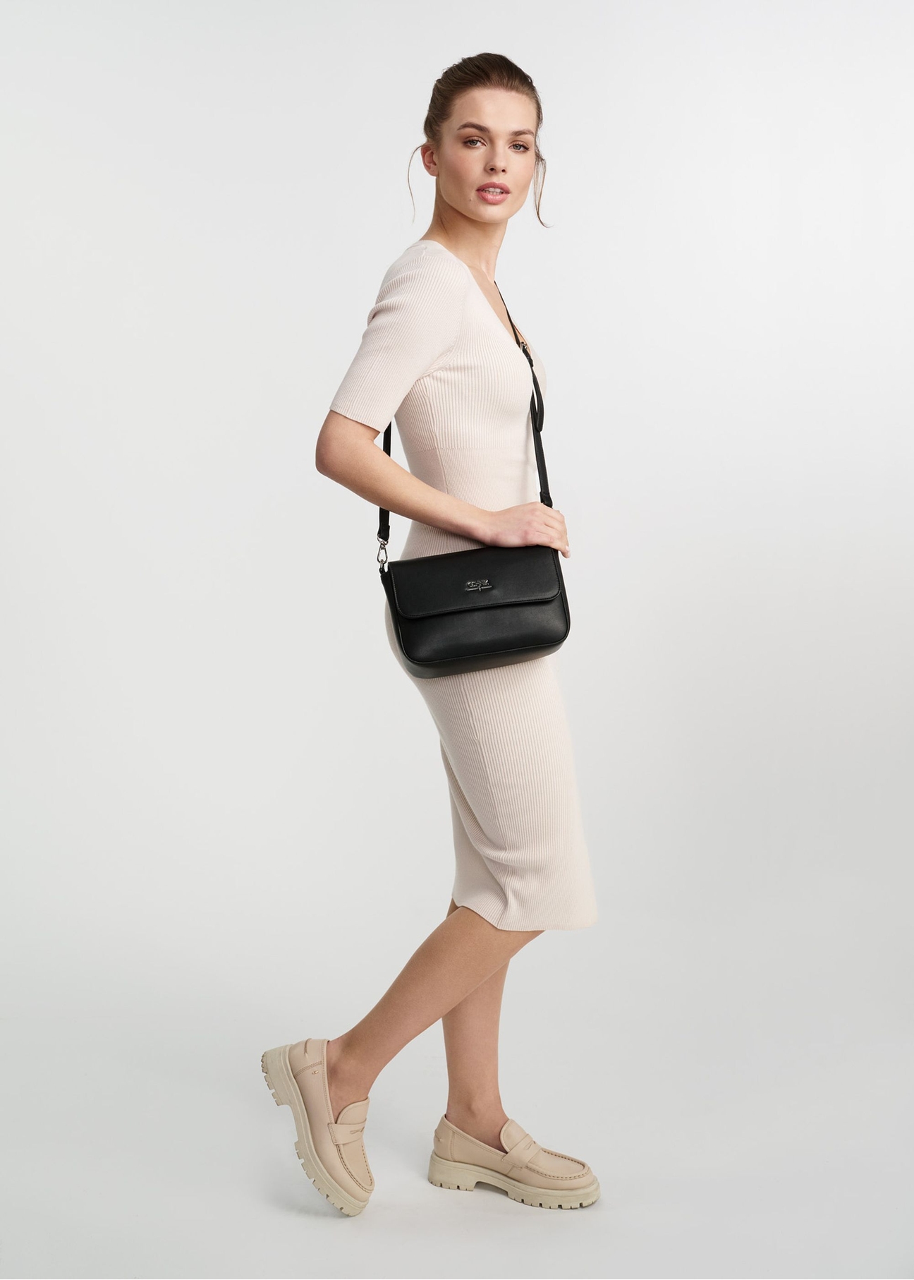 Black rectangular women's messenger bag TOREC-0930B-99(Z25), product view on model's shoulder. Full body visible.
