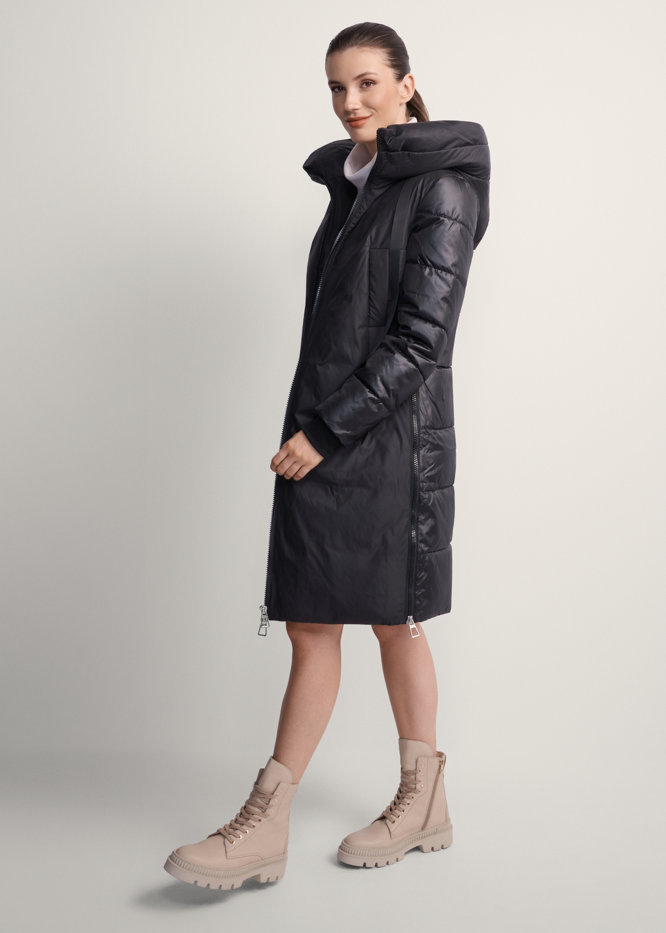 Women's black winter jacket with hood KURDT-0478-99(Z25), front view of the product on the model. Full body visible.