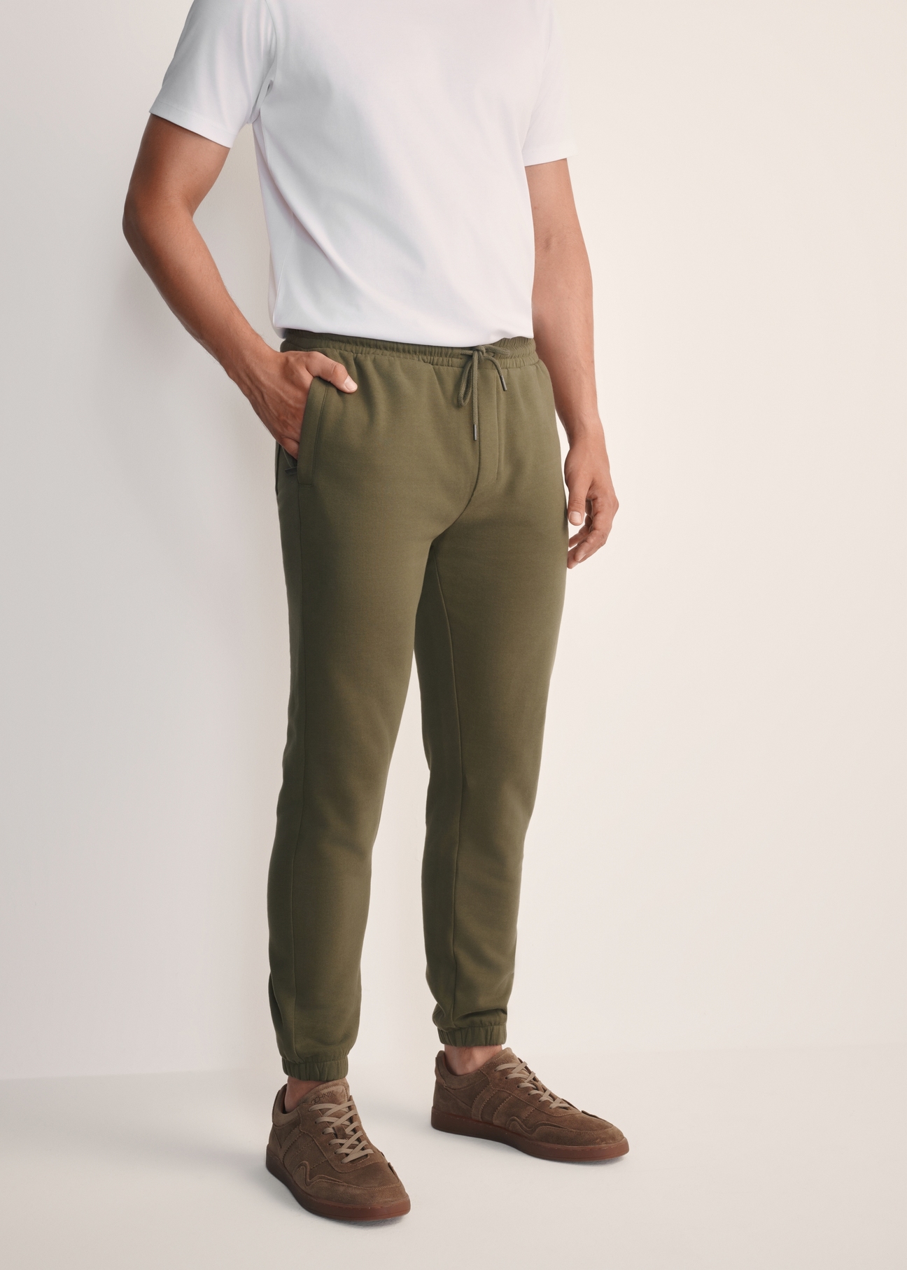 Men's khaki sweatpants SPOMT-0101-55(Z25), front view of the product on the model. Half of the silhouette visible.