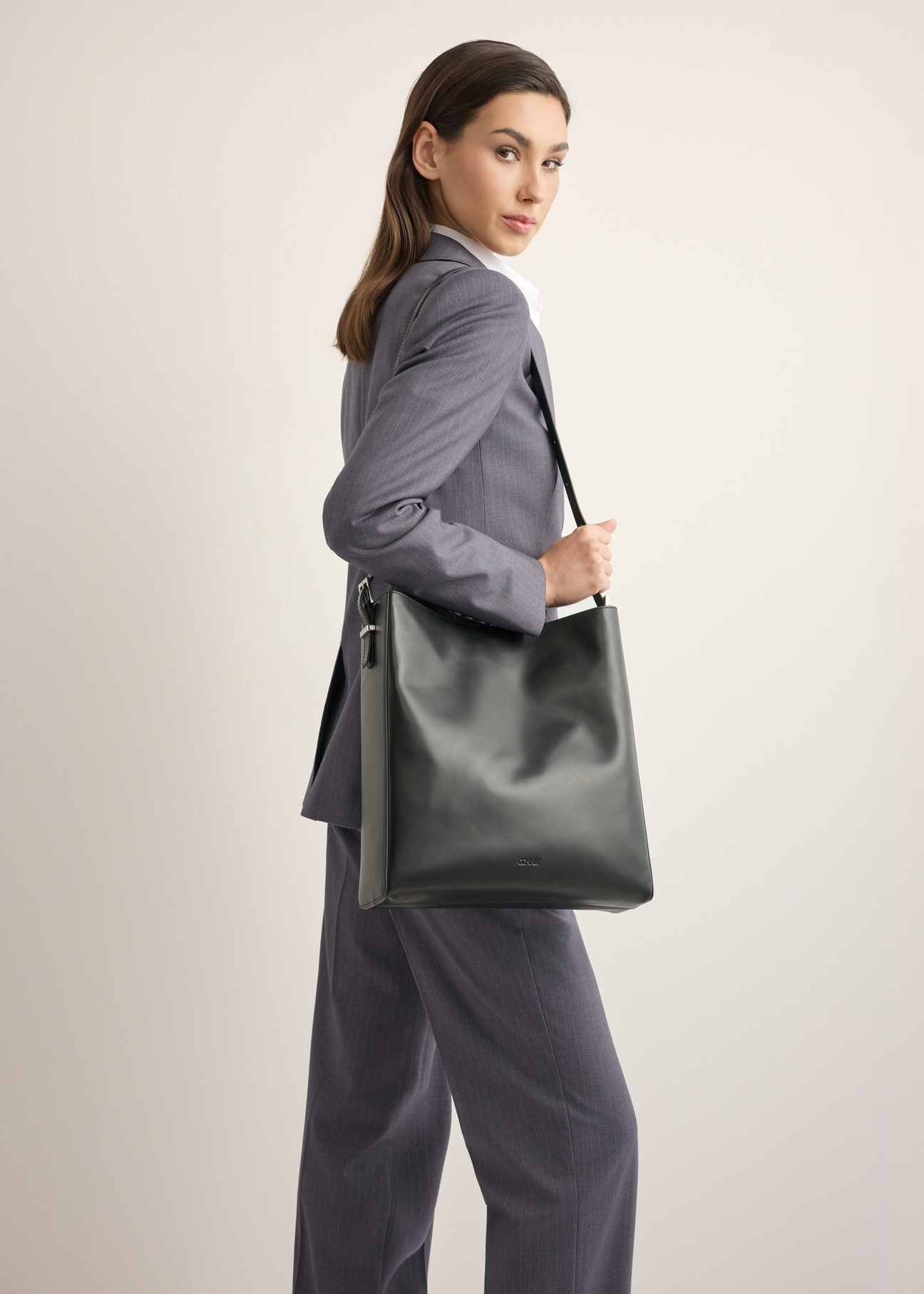 Black leather shopper bag TORES-1436-99(Z26), product view on model's shoulder. Half of silhouette visible.
