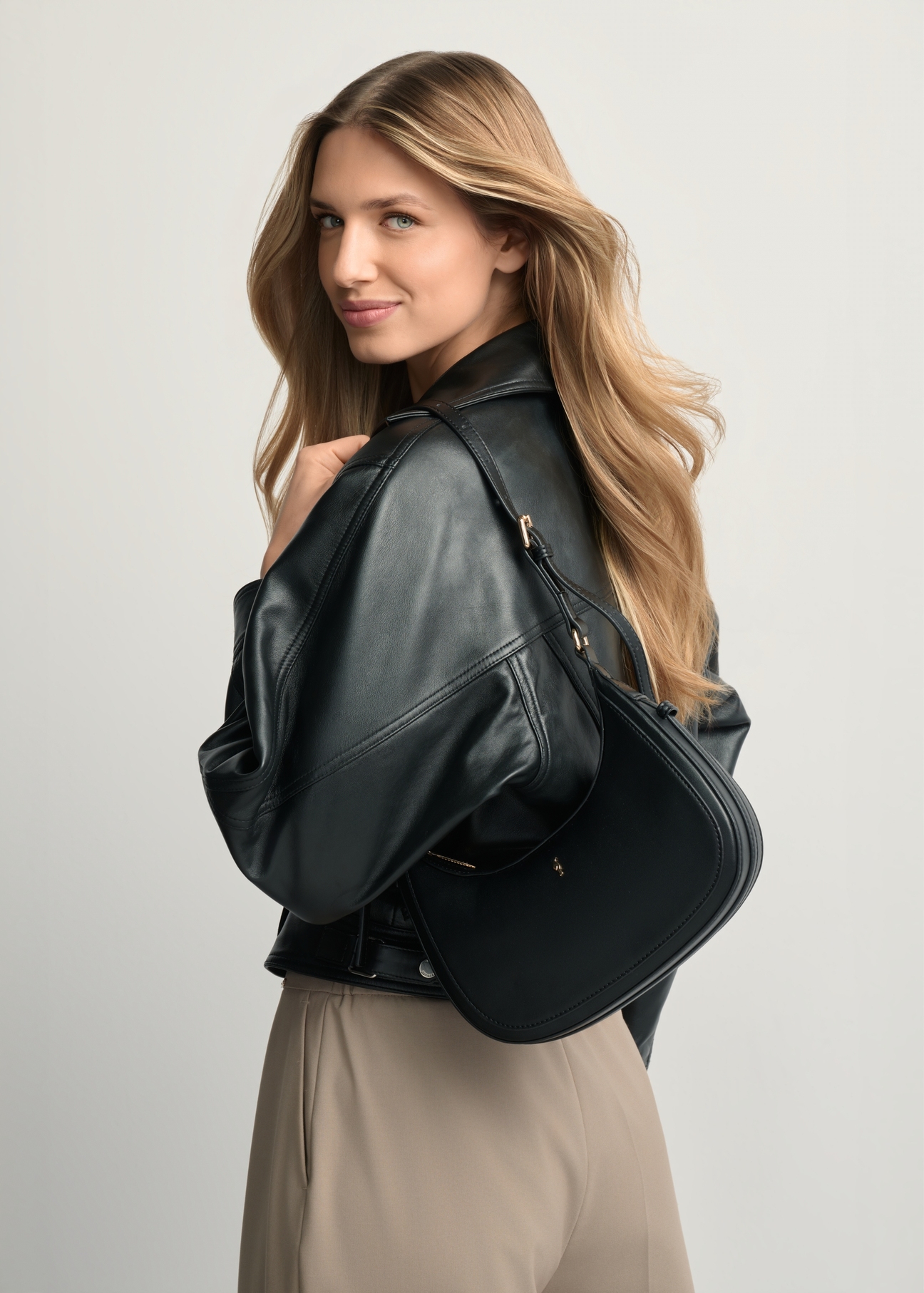 Small black hobo bag TOREC-1136-99(W26) - diagonal product view, with the model standing backwards against a light background. Half of the silhouette visible.