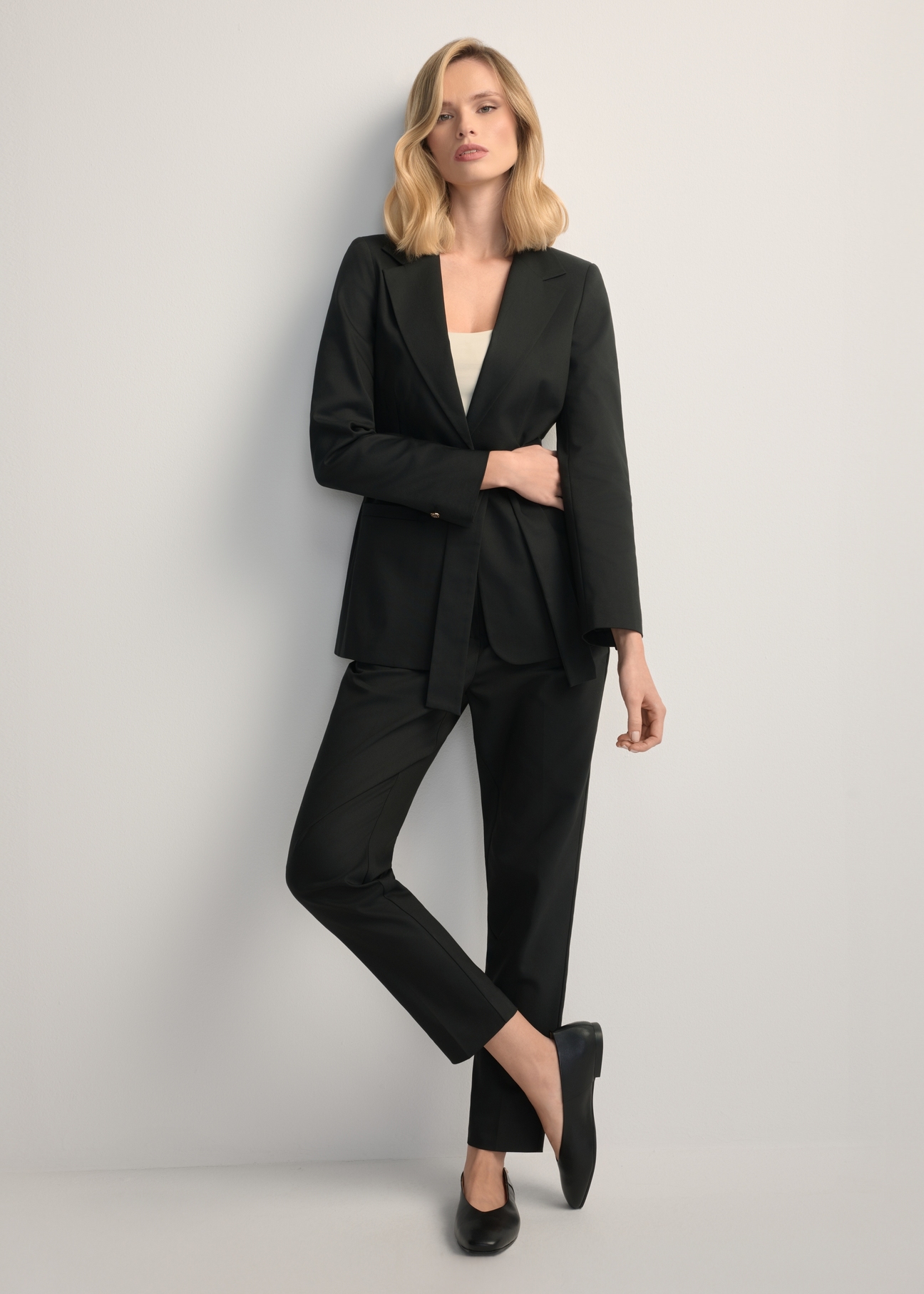 Women's black pleated trousers SPODT-0090-99(W25), front view of the product on the model. Full body visible.