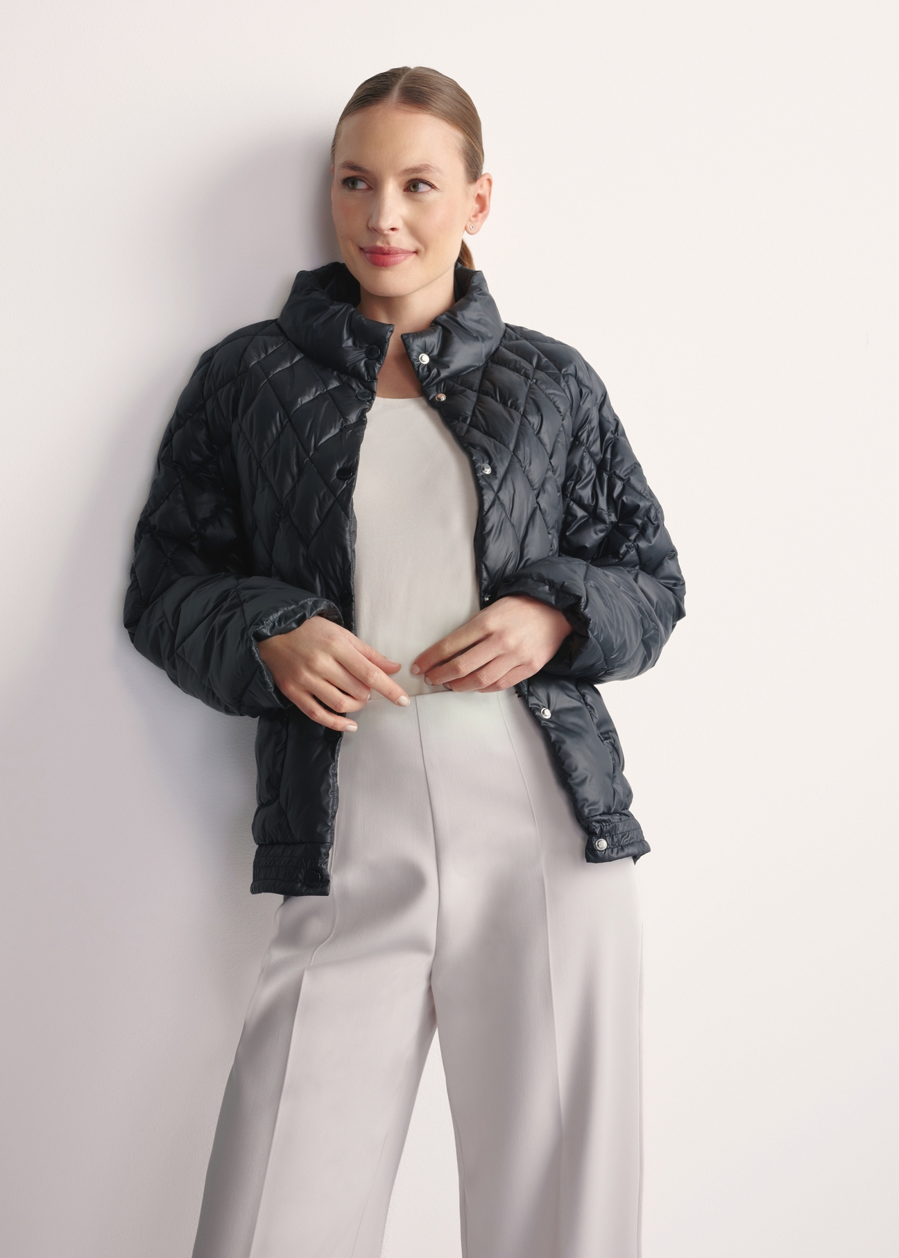 Black women's quilted jacket KURDT-0597-98(Z25), front view of the product on the model, half of the silhouette visible.