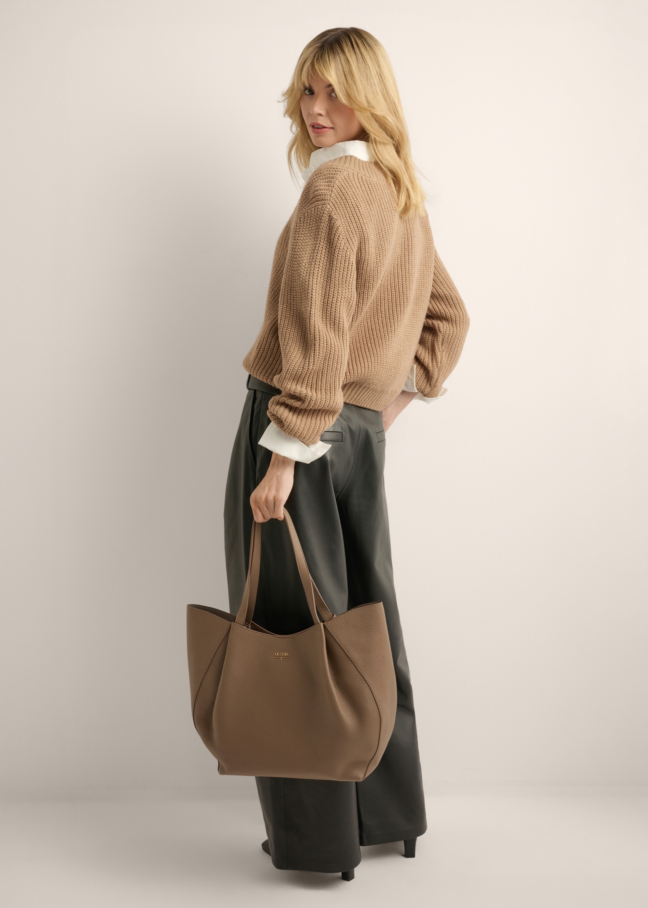 Women's leather shopper bag in cool beige TORES-1358-1K(Z26), front view of the product in the model's hand. Full body visible.