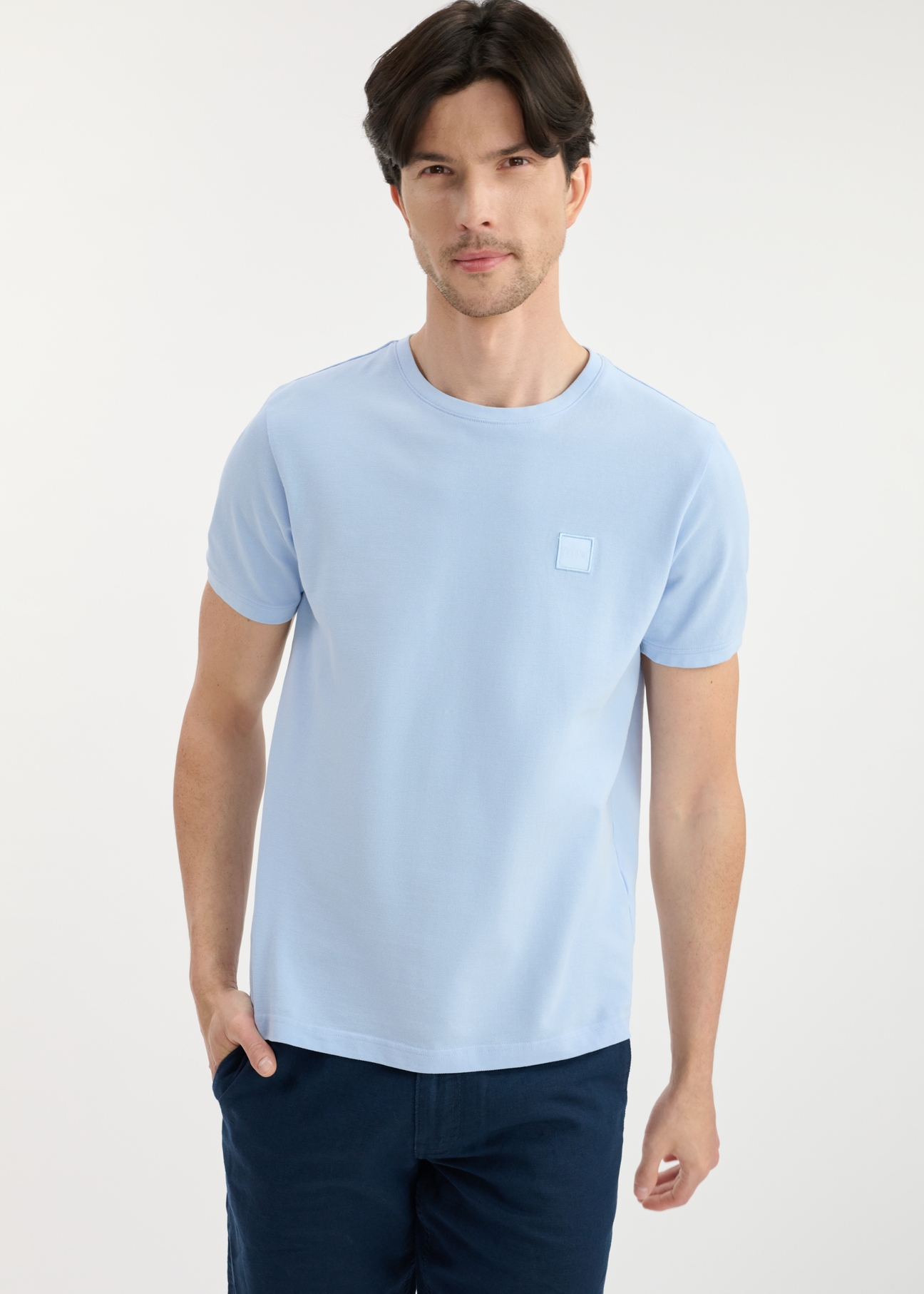 Light blue men's cotton T-shirt TSHMT-0100-60(W25), front view of the product on the model. Half of the silhouette visible.