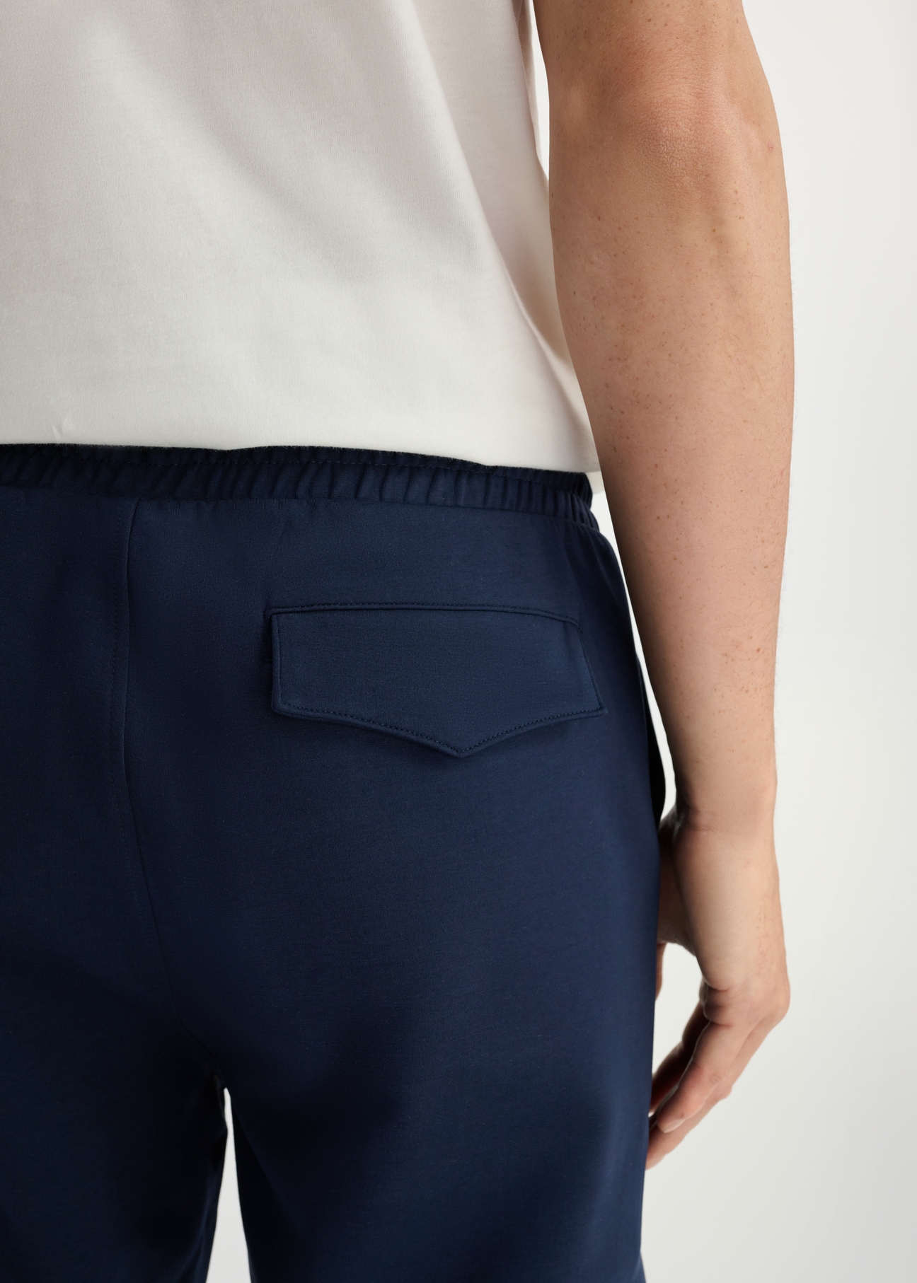 Navy blue men's sweatpants SPOMT-0109-69(W25) - close-up of detail from the back on the model on a white background.