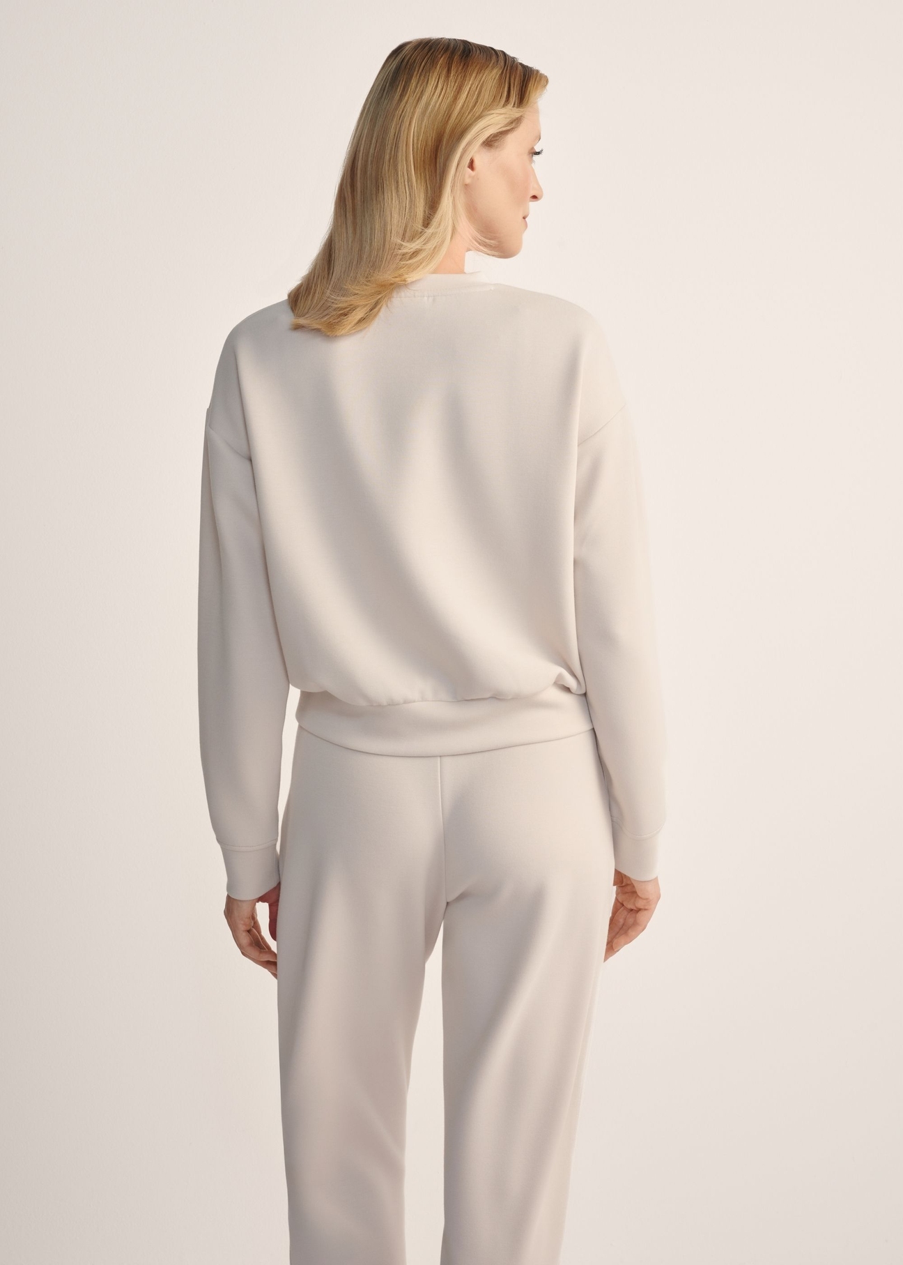 Light beige women's sweatshirt BLZDT-0119-1A(Z26), back view of the product on the model. Half of the silhouette visible.