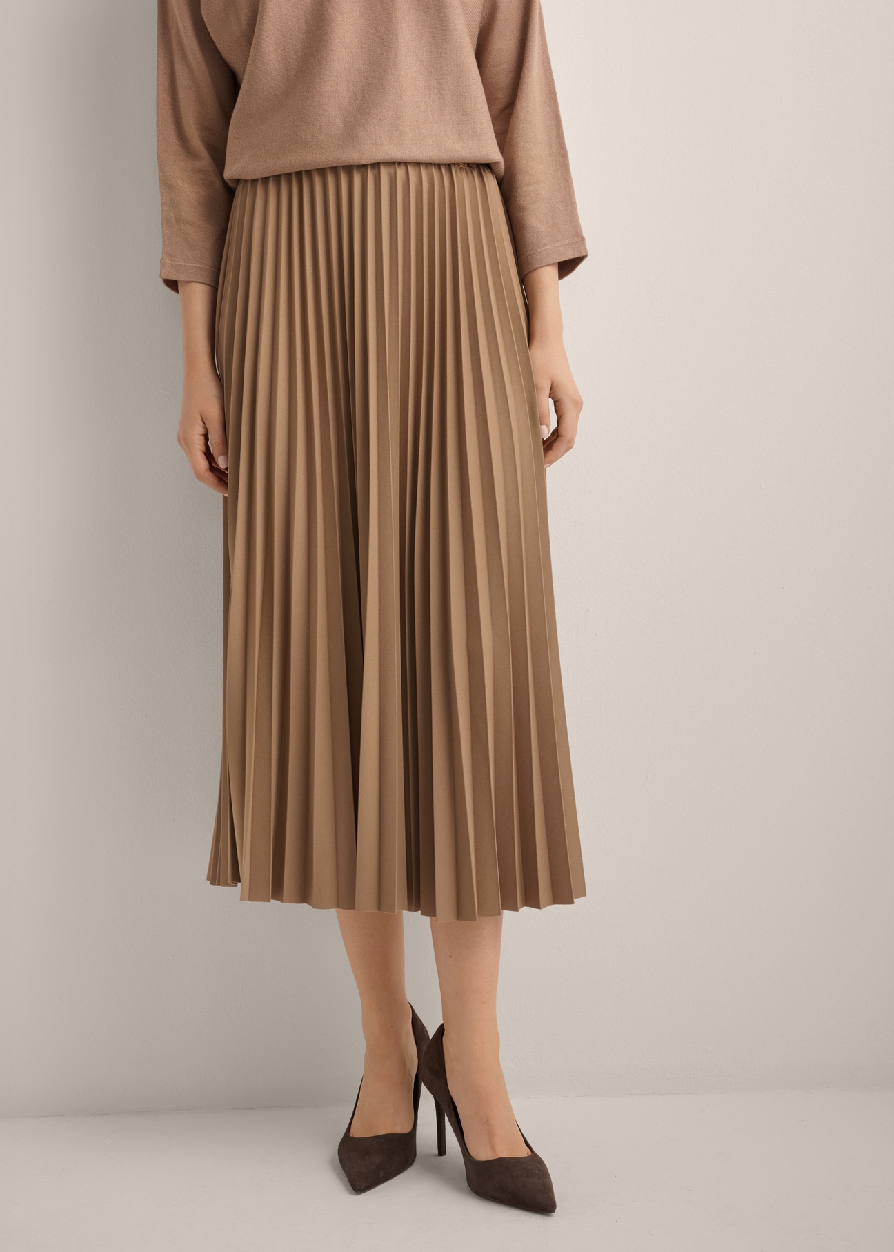 Camel Pleated Midi Skirt SPCDT-0096-1D(Z26), front view of the product on the model. Half of the silhouette visible.