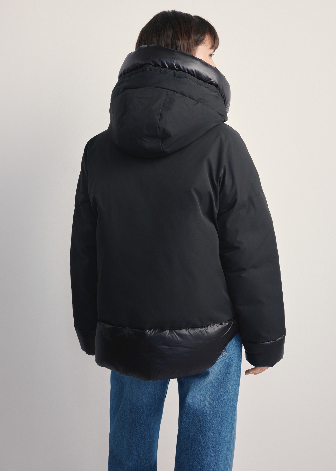 Black oversized women's jacket KURDT-0605-99(Z25), back view of the product on the model. Half of the silhouette visible.